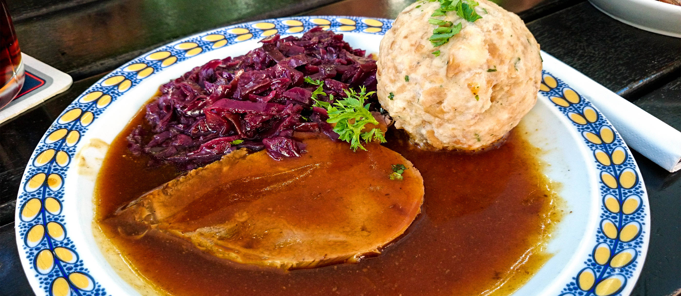 meat 桌布 壁紙 — 一盤豐盛的燉肉，配上紅椰菜和馬鈴薯糰子，並以歐芹點綴。