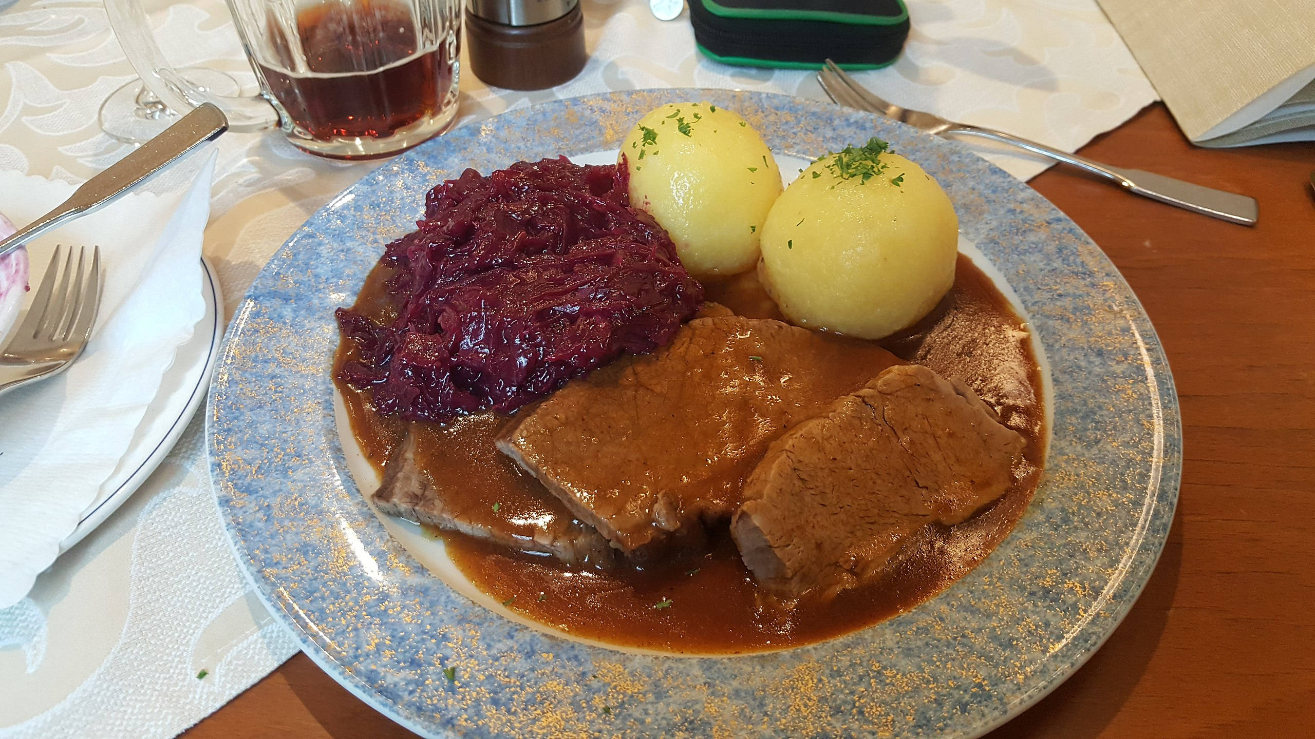 meat 桌布 壁紙 — 一盤豐盛的燉肉配上濃郁肉汁、紅椰菜和水煮馬鈴薯，以歐芹點綴，放在藍色斑點盤上。