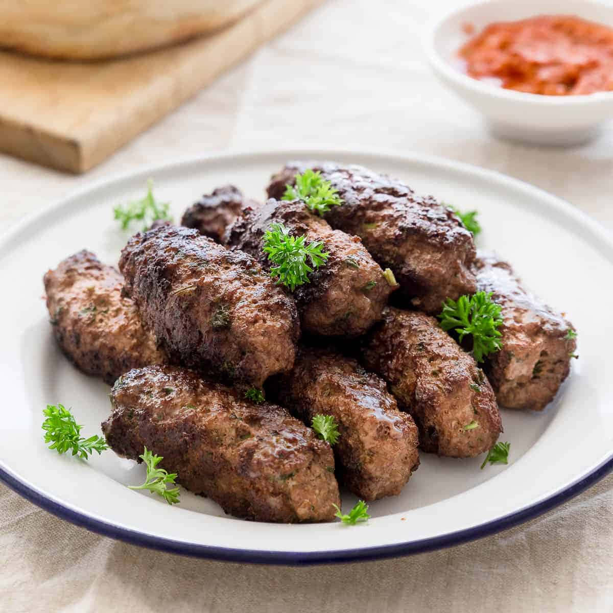 meat 桌布 壁紙 — 一盤金黃色的烤牛肉丸，飾以新鮮歐芹，並附上紅醬。
