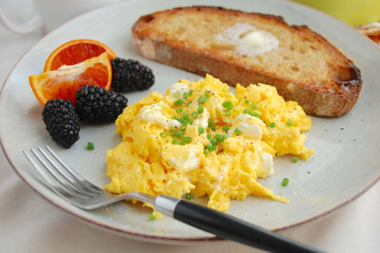 Scrambled Egg 桌布 壁紙 — 一盤鬆軟炒蛋，上面撒上細香蔥和起司，旁邊有奶油吐司、黑莓和柳橙片。
