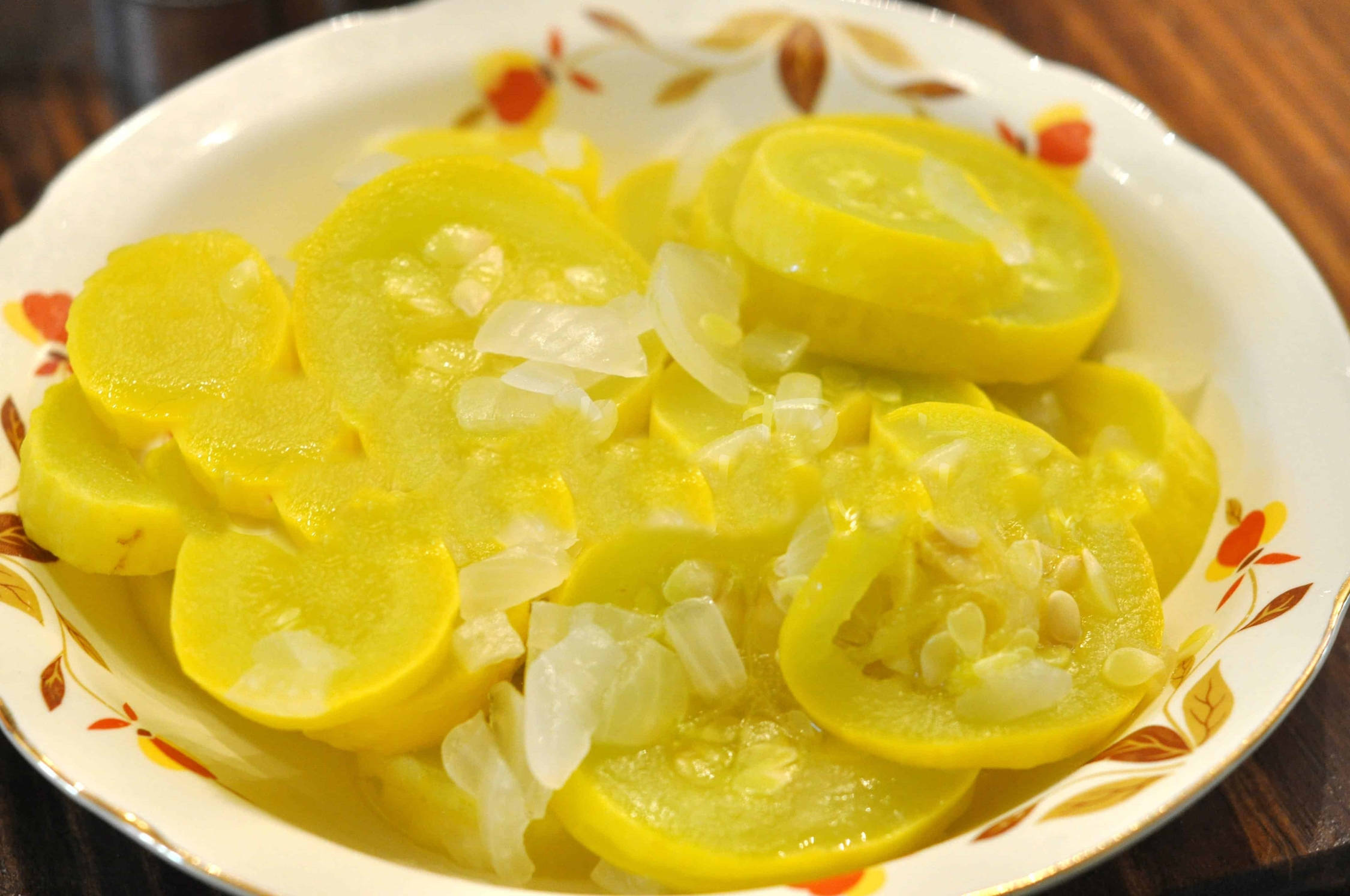 Fruits And Vegetables 桌布 壁紙 — 一盤鮮黃色的南瓜片，上面放著半透明的洋蔥，放在一個花卉圖案的盤子上。