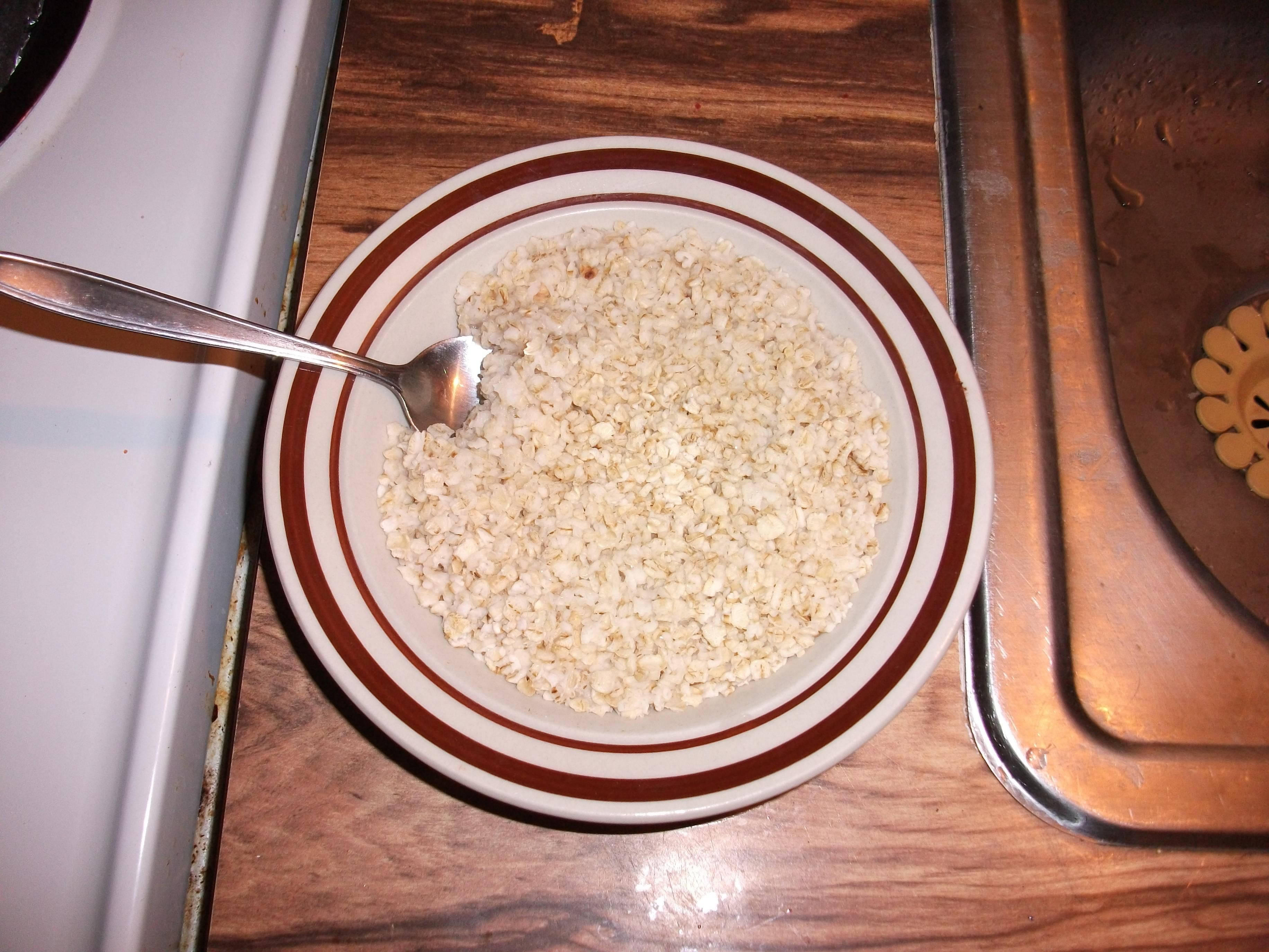 烹飪 桌布 壁紙 — 一碗乾燕麥片配湯匙放在木製檯面上，旁邊是不鏽鋼水槽。