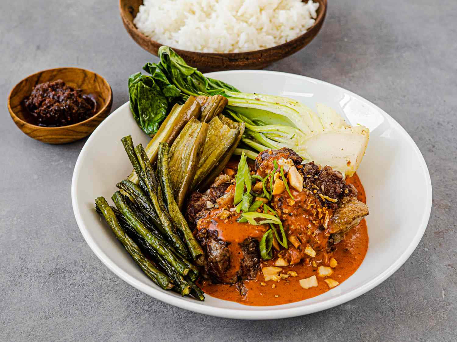meat 桌布 壁紙 — 一碗充滿活力的濃郁紅咖哩，配有嫩肉、青豆和白菜，搭配白飯和深色醬汁。