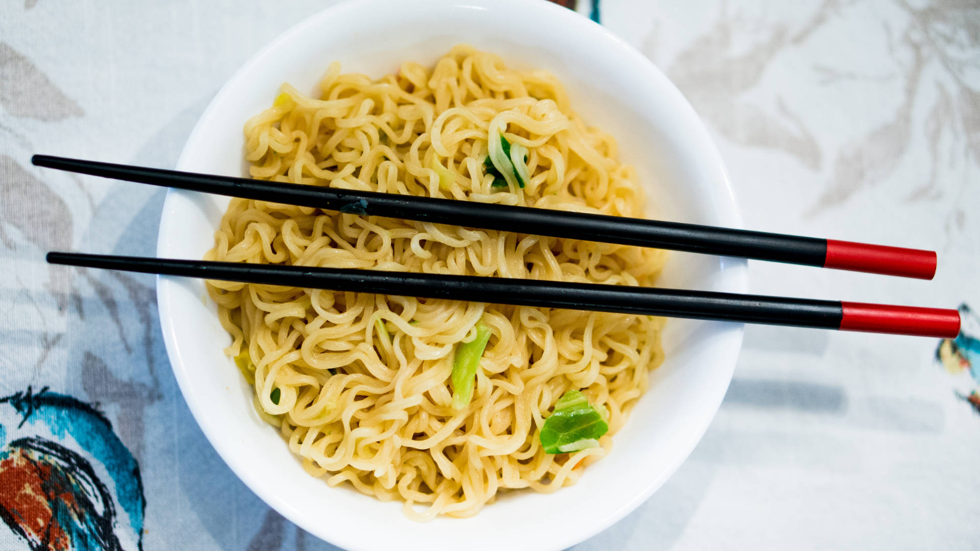 Pasta 桌布 壁紙 — 一碗冒煙的即食麵，上面放著青蔥和黑色紅頭筷子。