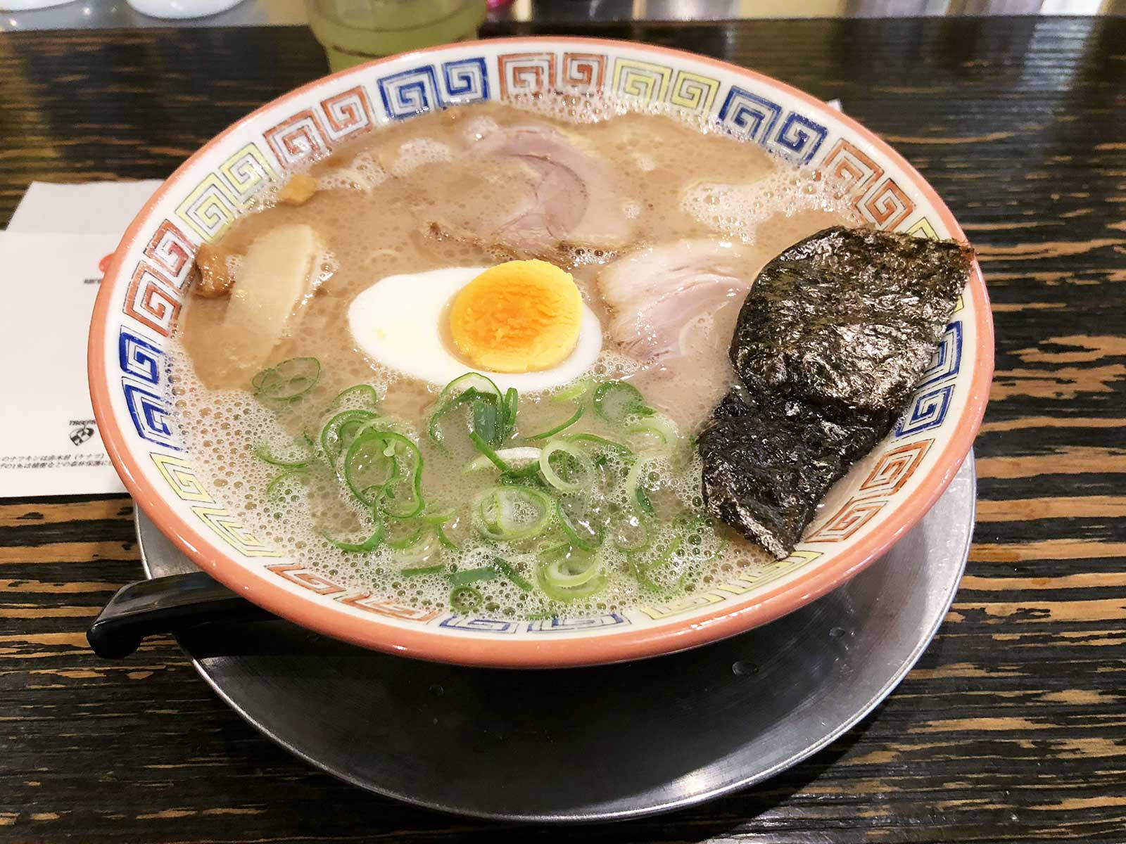 Healthy Food 桌布 壁紙 — 一碗冒煙的拉麵，配有溏心蛋、青蔥和海苔，放在深色木桌上。