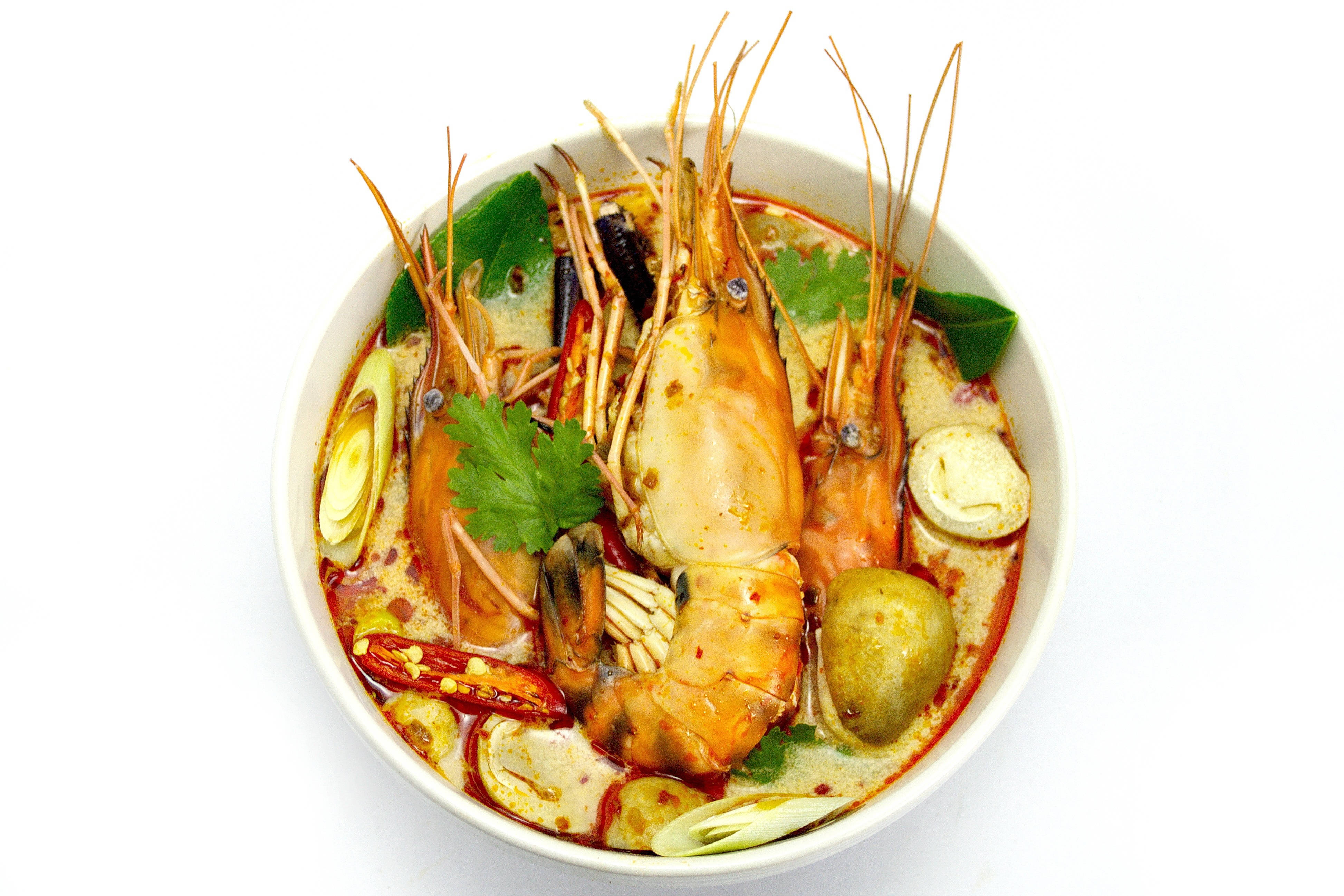 Prawns 桌布 壁紙 — 一碗冒煙的泰式冬陰功湯，內有大蝦、辣椒、青檸葉和香草，襯托在潔白的背景上。