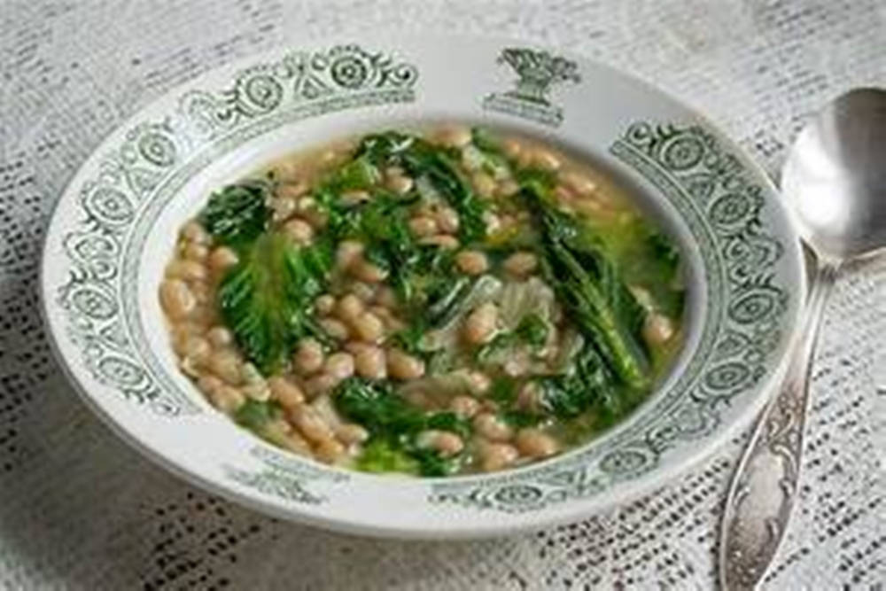 beans 桌布 壁紙 — 一碗冒煙的白豆綠葉湯放在蕾絲桌布上，旁邊有一把華麗的湯匙。