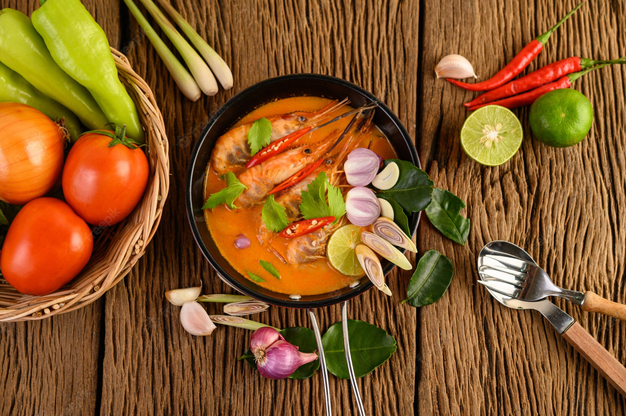Food Photography 桌布 壁紙 — 一碗冒煙的鮮橙色蝦咖哩，周圍放滿新鮮泰國食材，置於鄉村風木桌上。