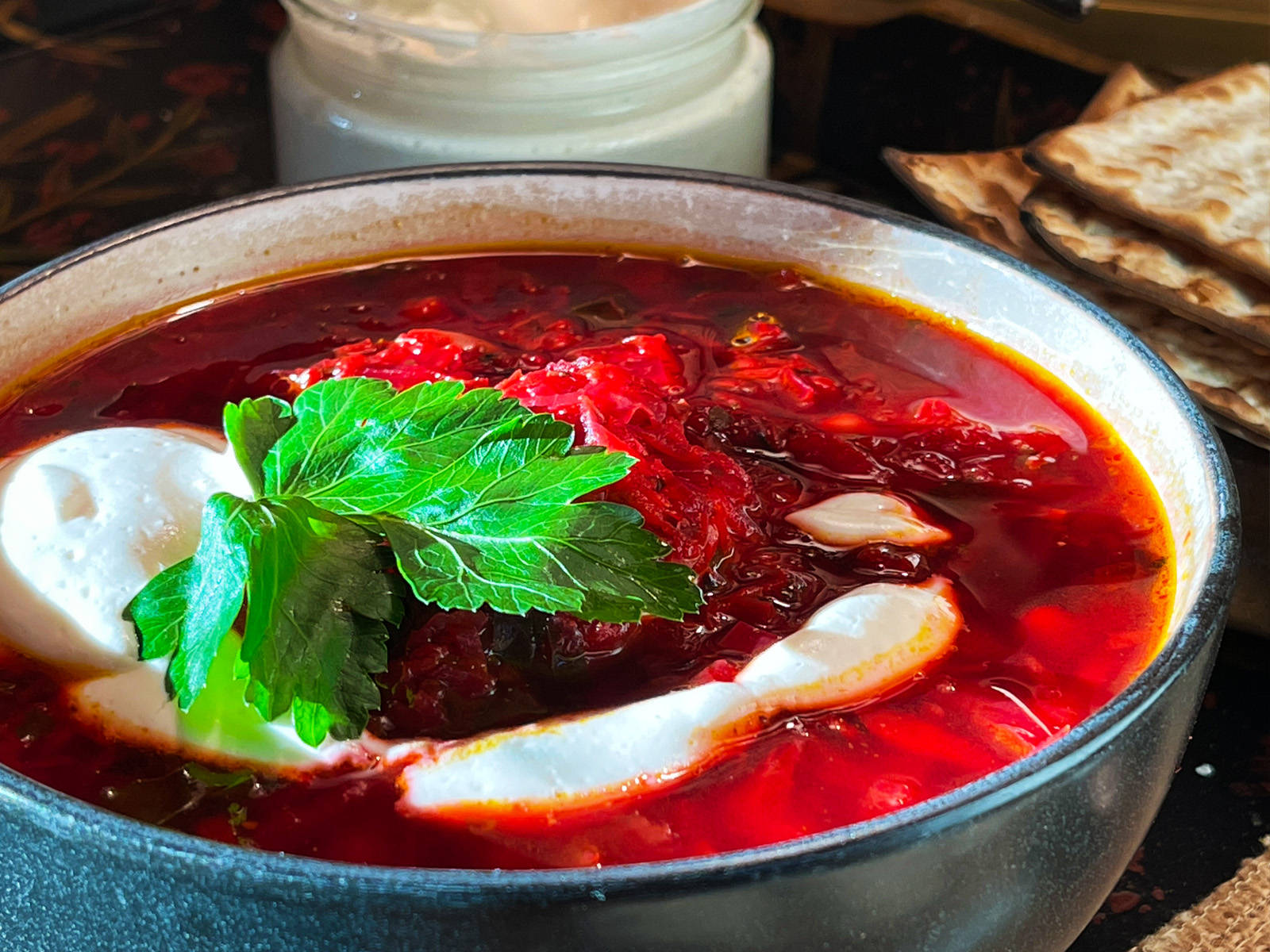 beetroot 桌布 壁紙 — 一碗冒著熱氣的鮮紅色羅宋湯，上面放著酸奶油和新鮮歐芹，旁邊放著香脆的扁麵包。