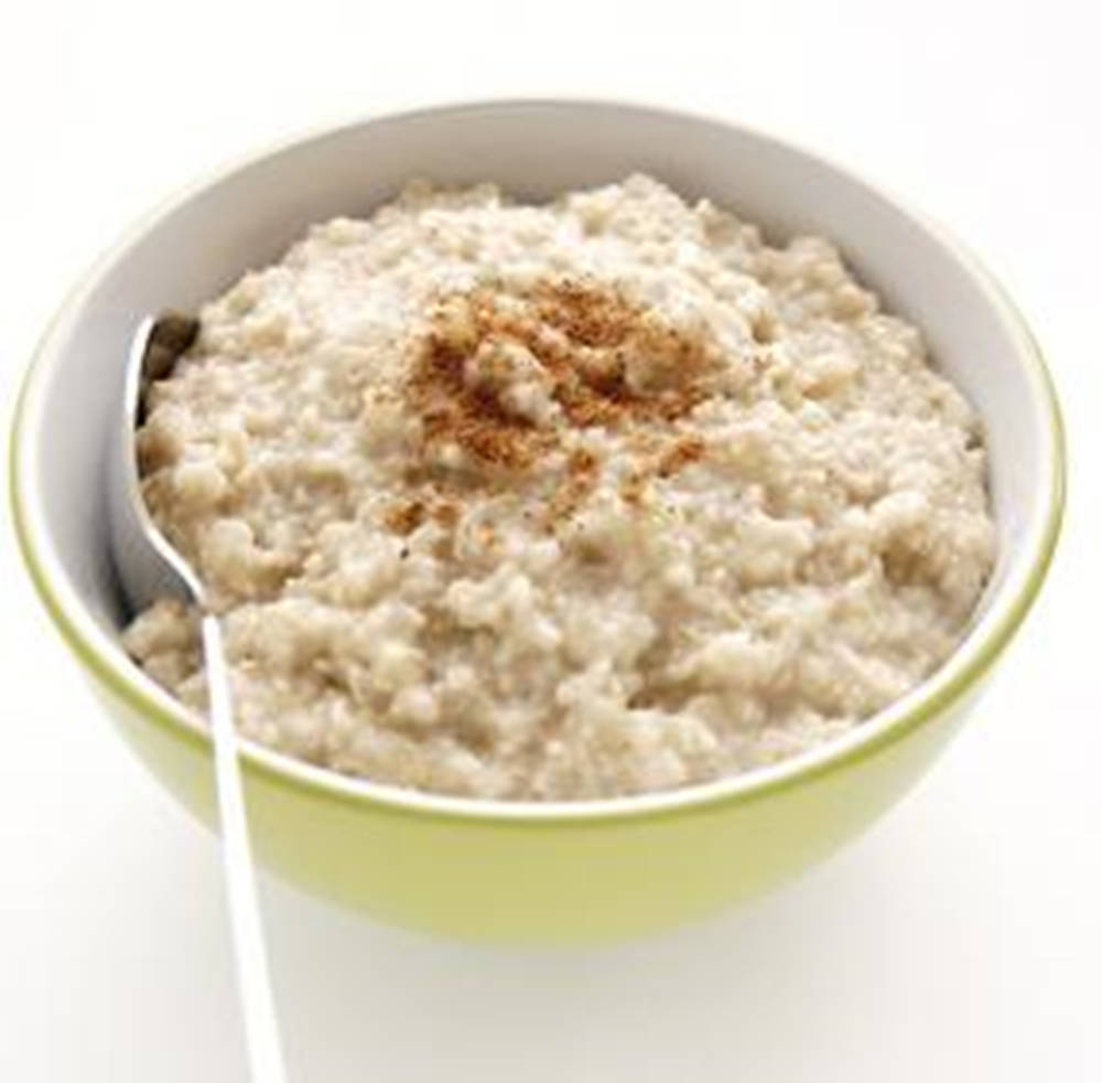 烹飪 桌布 壁紙 — 一碗奶油狀的燕麥片，上面撒了肉桂粉，放在淺綠色陶瓷碗裡，裡面有湯匙。