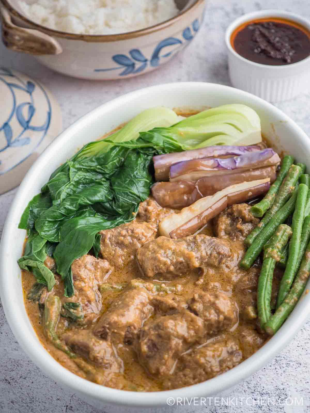 Vegetables 桌布 壁紙 — 一碗熱氣騰騰的濃郁棕色咖哩，內有嫩肉、青豆、白菜和茄子，配上白飯和沾醬。
