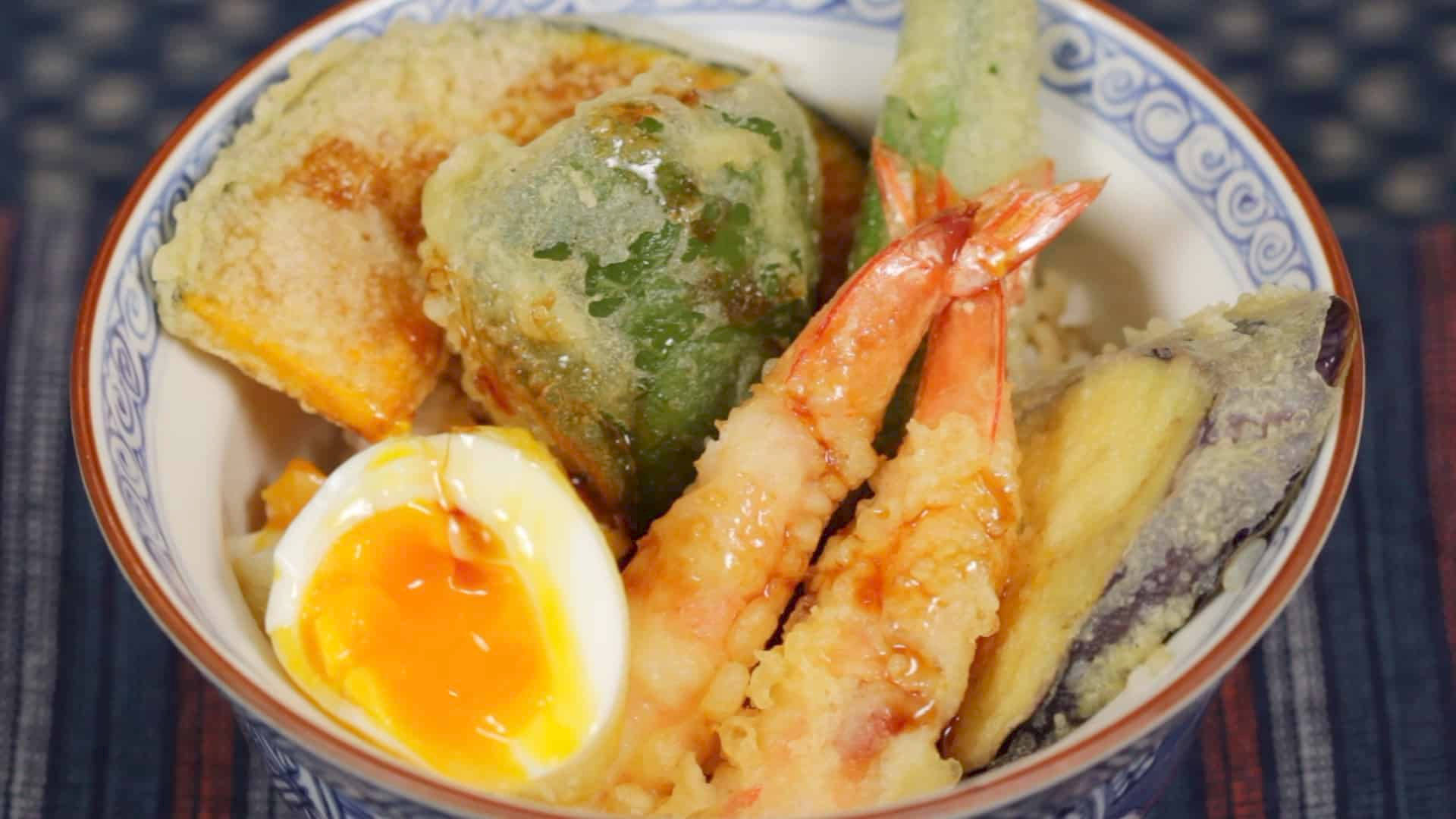 shrimp 桌布 壁紙 — 一碗熱騰騰的天婦羅特寫，包括蝦、茄子和蔬菜，配上溏心蛋並淋上醬汁。