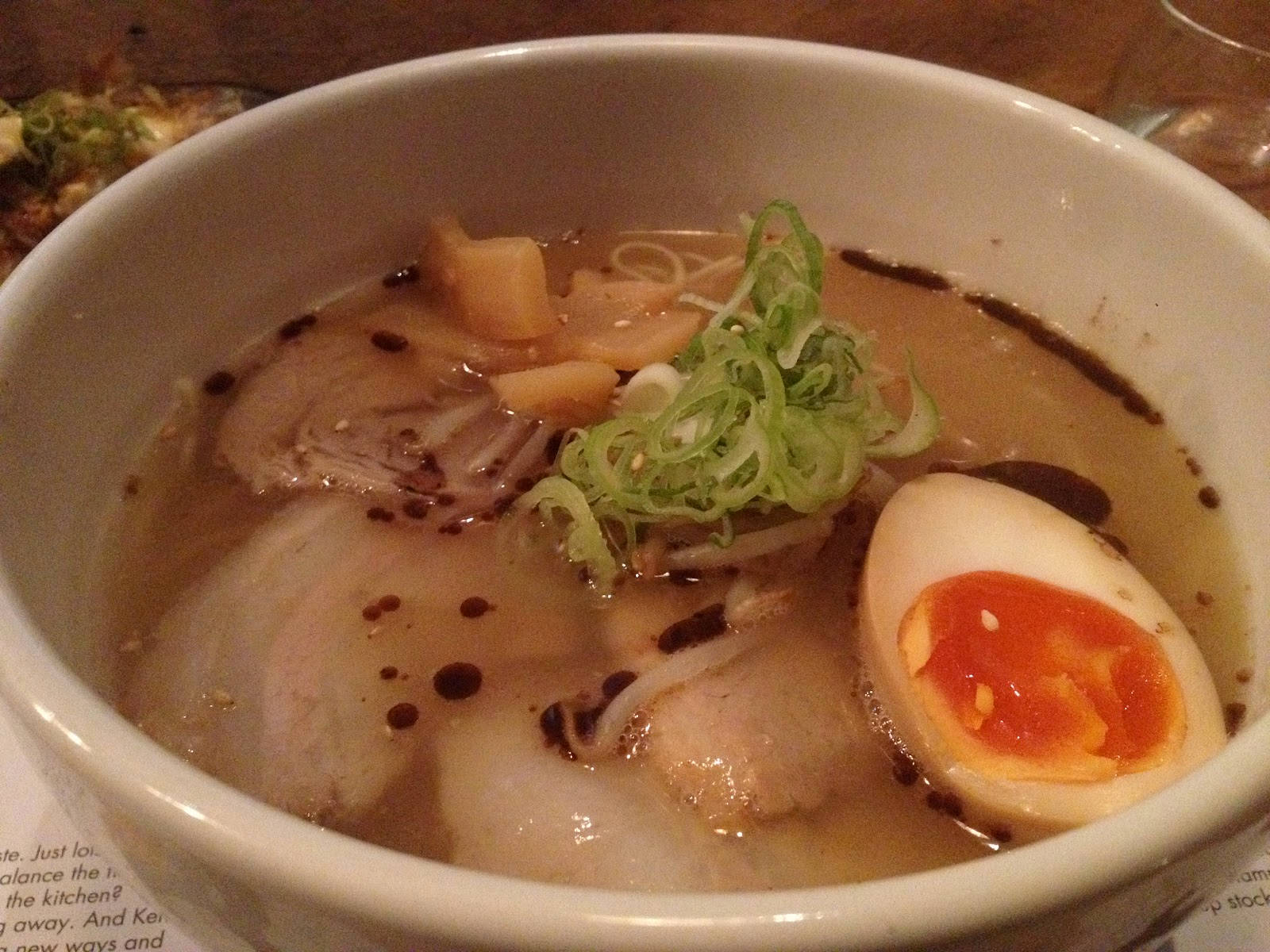 Ramen 桌布 壁紙 — 一碗熱騰騰的拉麵，配上溏心蛋、切片青蔥和嫩滑豬肉，浸在濃郁湯頭中。