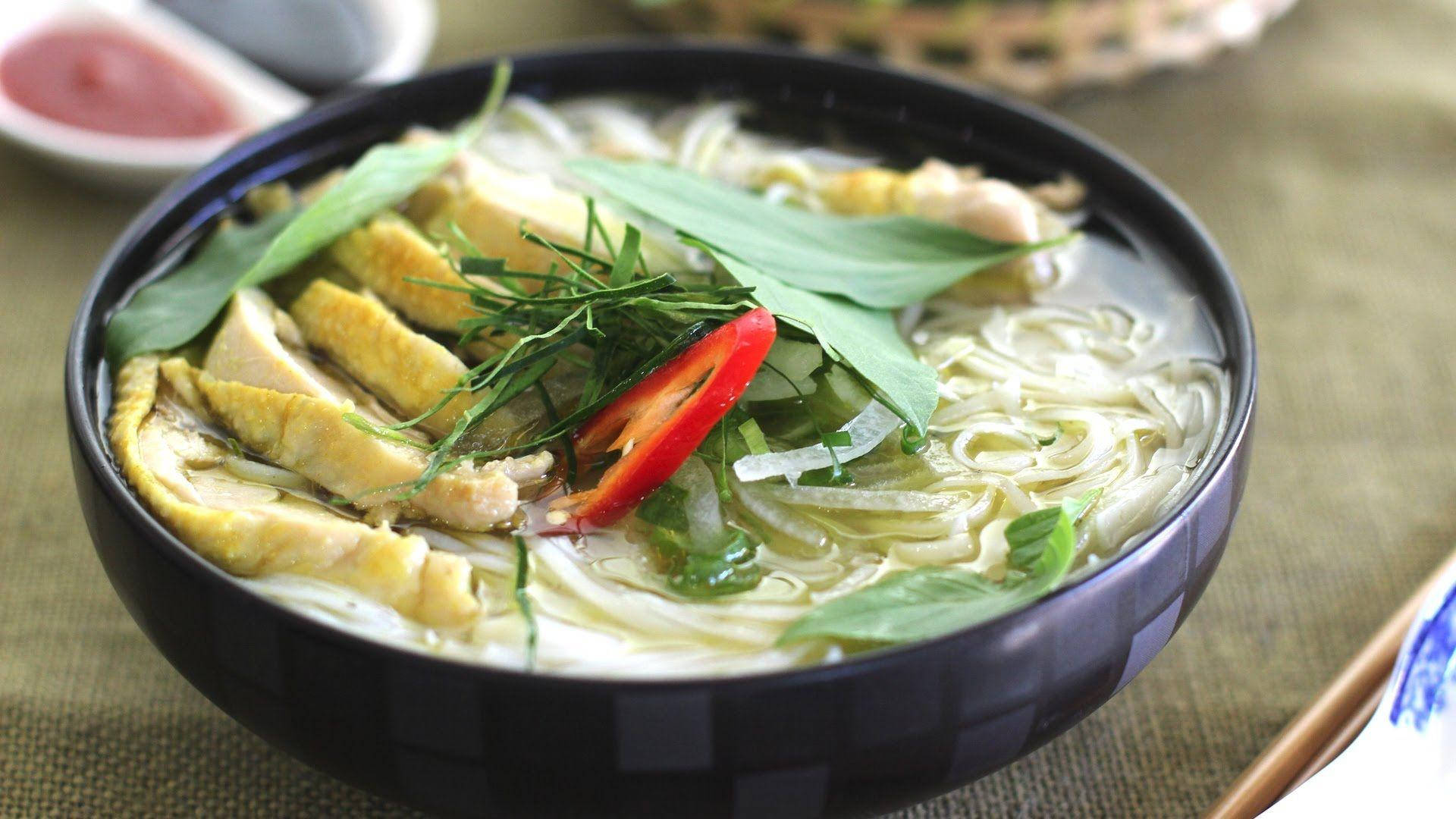 Chicken 桌布 壁紙 — 一碗熱騰騰的河粉，配上嫩雞肉片、米粉、新鮮香草，並在深色碗中點綴一片鮮紅的辣椒片。