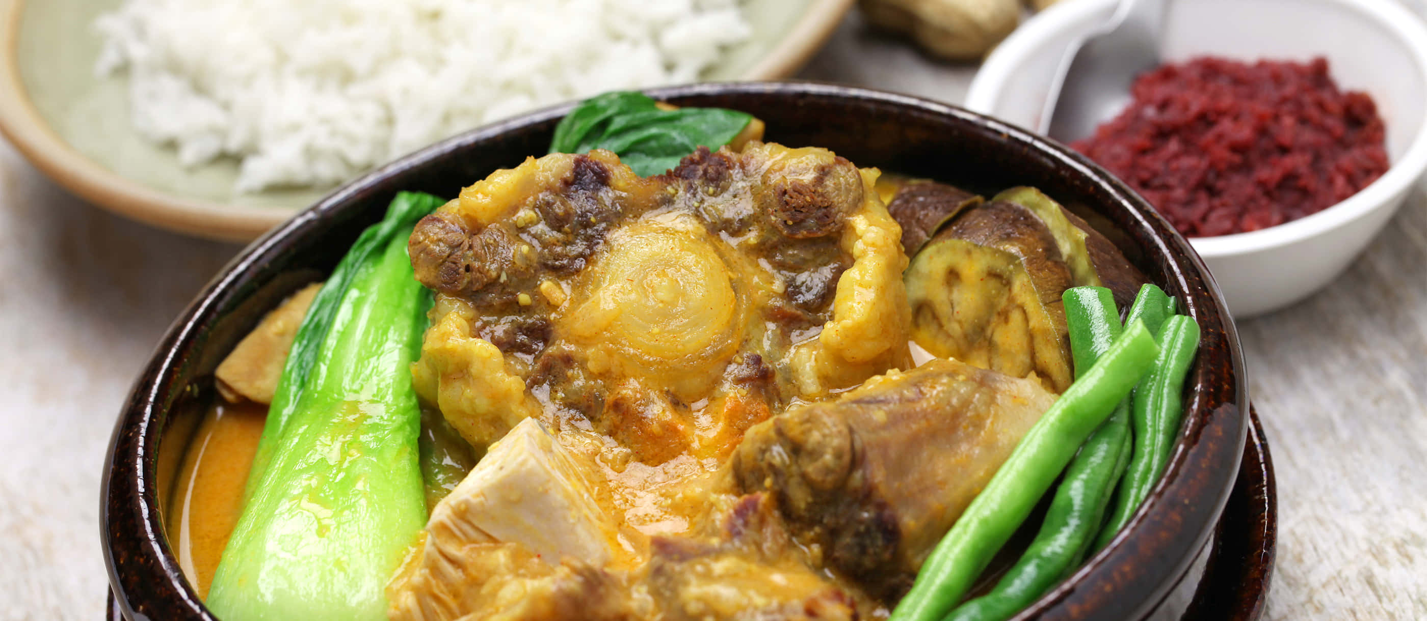 meat 桌布 壁紙 — 一碗熱騰騰的濃郁咖哩，配上嫩肉、蔬菜和米飯，並以新鮮蔬菜點綴。