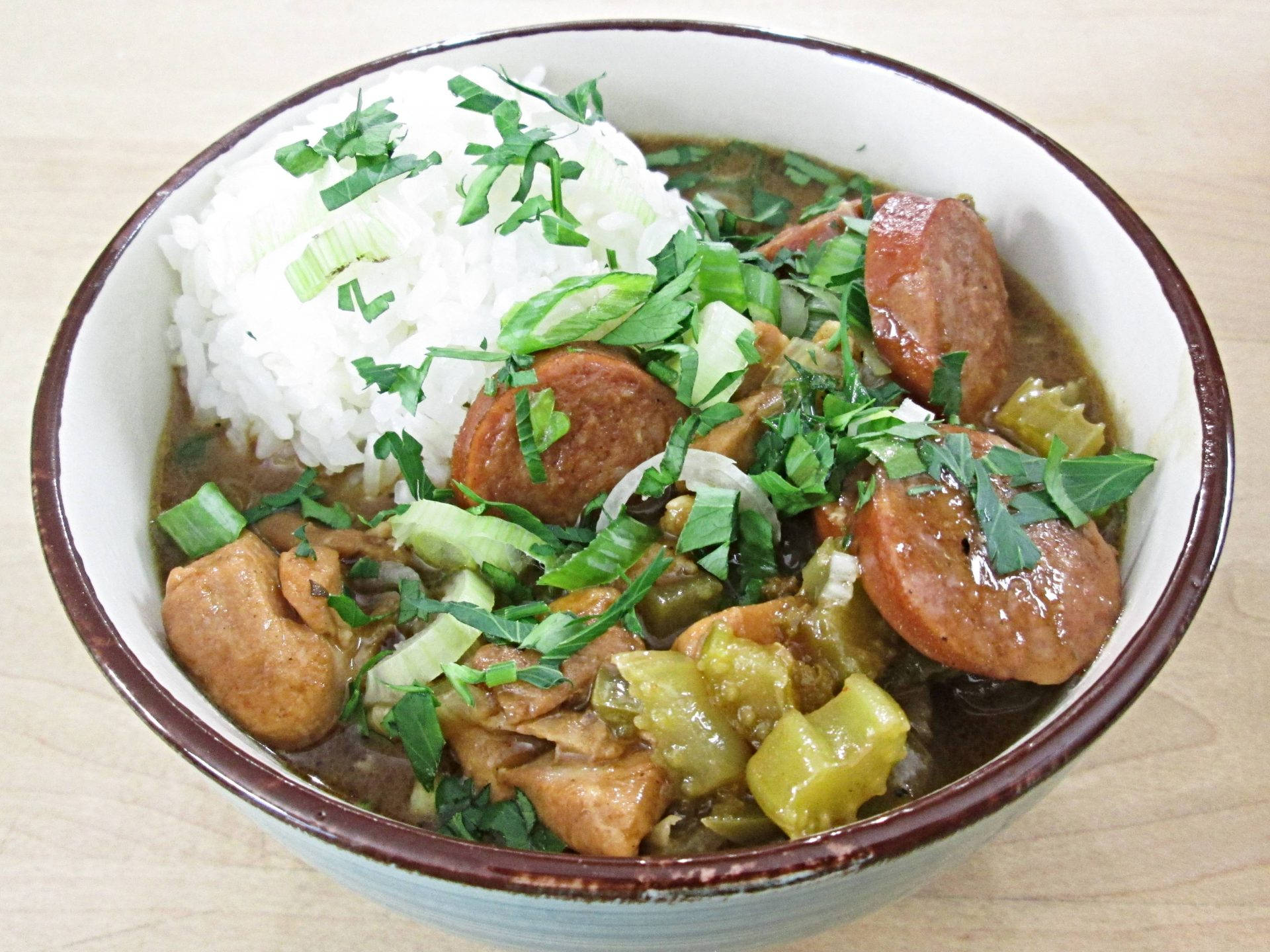 Food Photography 桌布 壁紙 — 一碗熱騰騰的濃郁秋葵湯，配以香腸、雞肉和青椒，放在白飯上，並以新鮮歐芹裝飾。