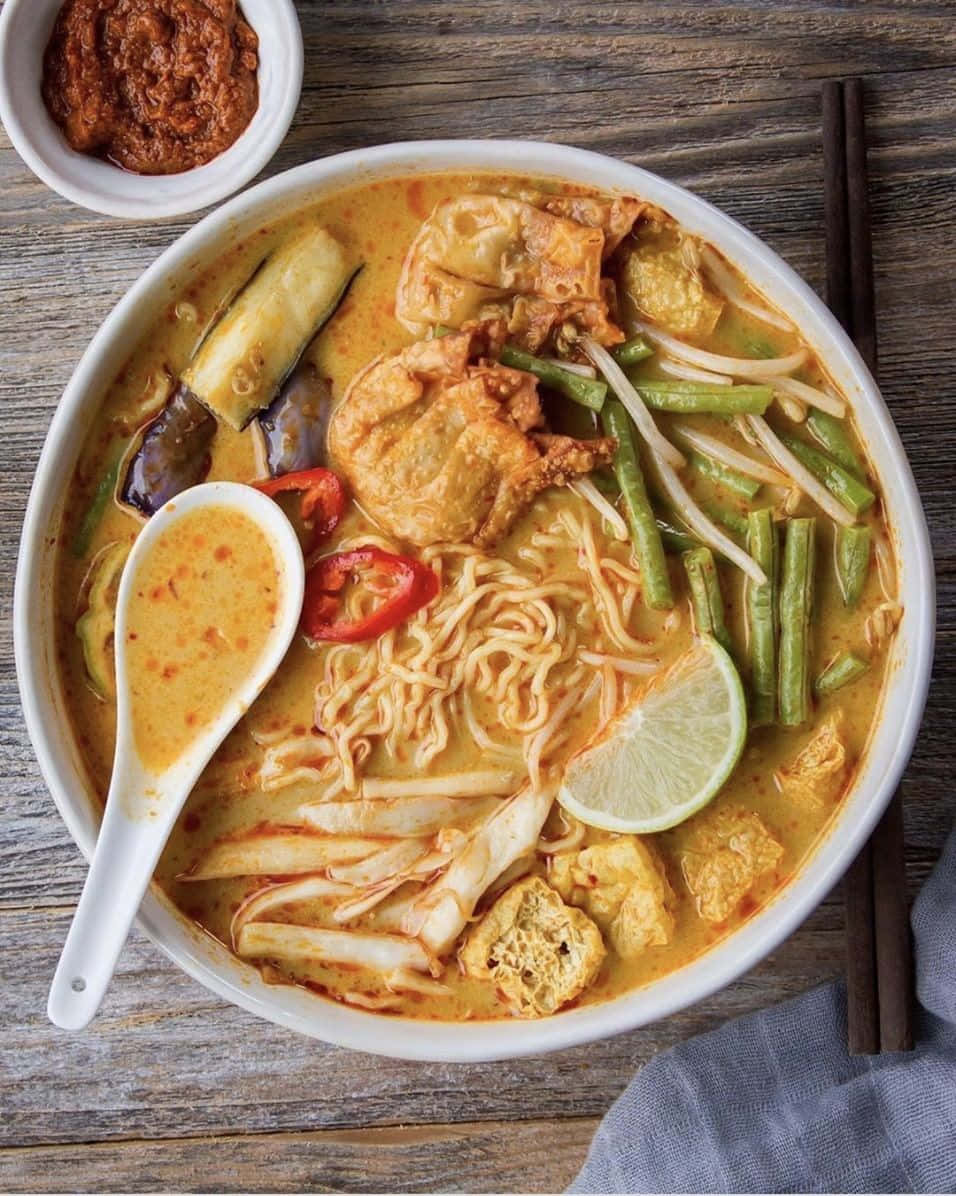 Delicious Food 桌布 壁紙 — 一碗熱騰騰的濃郁黃咖哩湯麵，配上豆腐、豆芽、青檸和辣椒，放在質樸的木桌上。