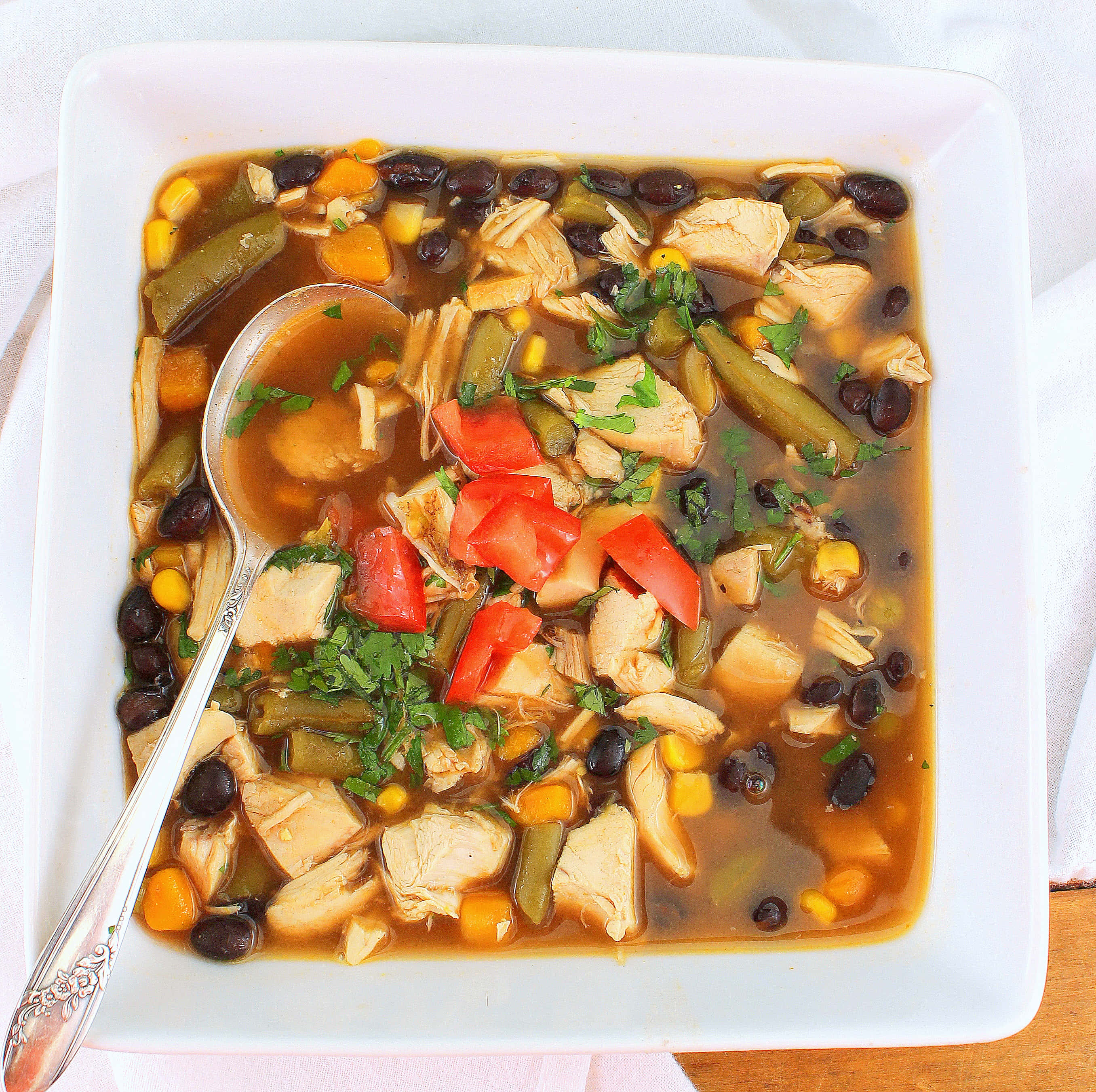 Black Bean Soup 桌布 壁紙 — 一碗熱騰騰的豐盛雞肉玉米餅湯，配上黑豆、玉米和新鮮香菜裝飾。