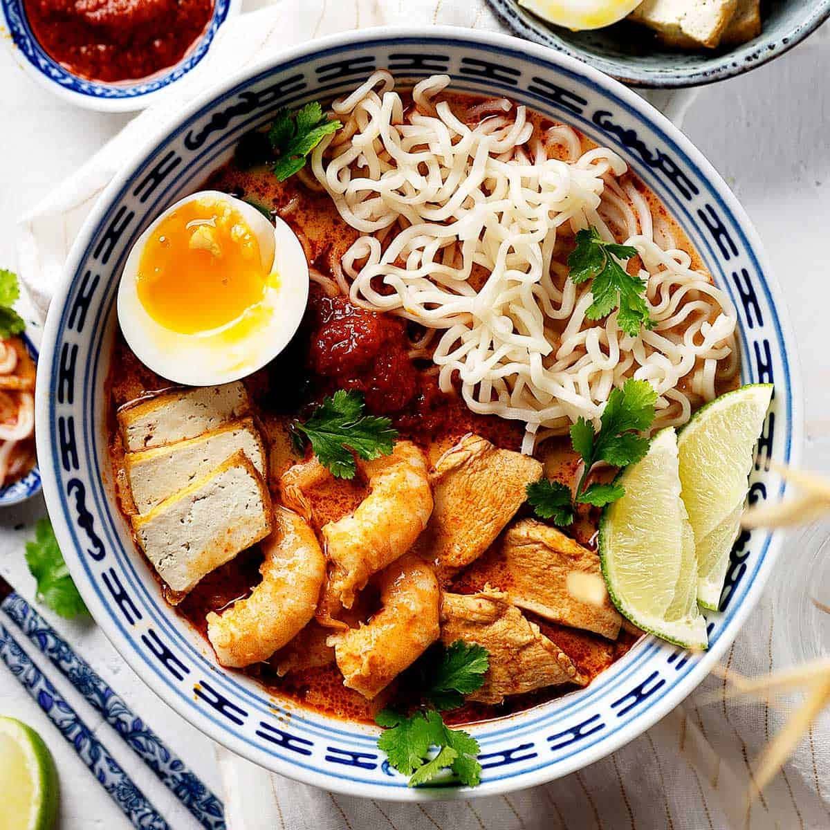 Food Photography 桌布 壁紙 — 一碗熱騰騰的辣味湯麵，配上溏心蛋、萊姆角和新鮮香菜。