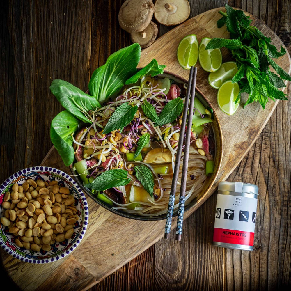 Food Photography 桌布 壁紙 — 一碗色彩繽紛的湯麵，上面放著新鮮的綠色芽菜、萊姆和花生，放在一個質樸的木板上。