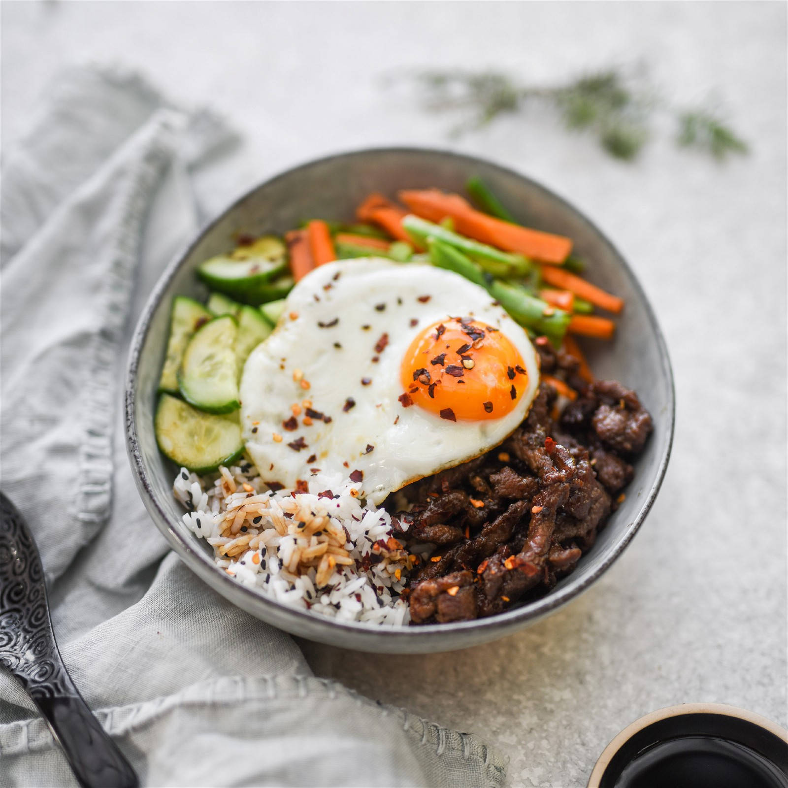 烹飪 桌布 壁紙 — 一碗色彩繽紛的米飯、牛肉和蔬菜，上面放著太陽蛋和紅辣椒片。