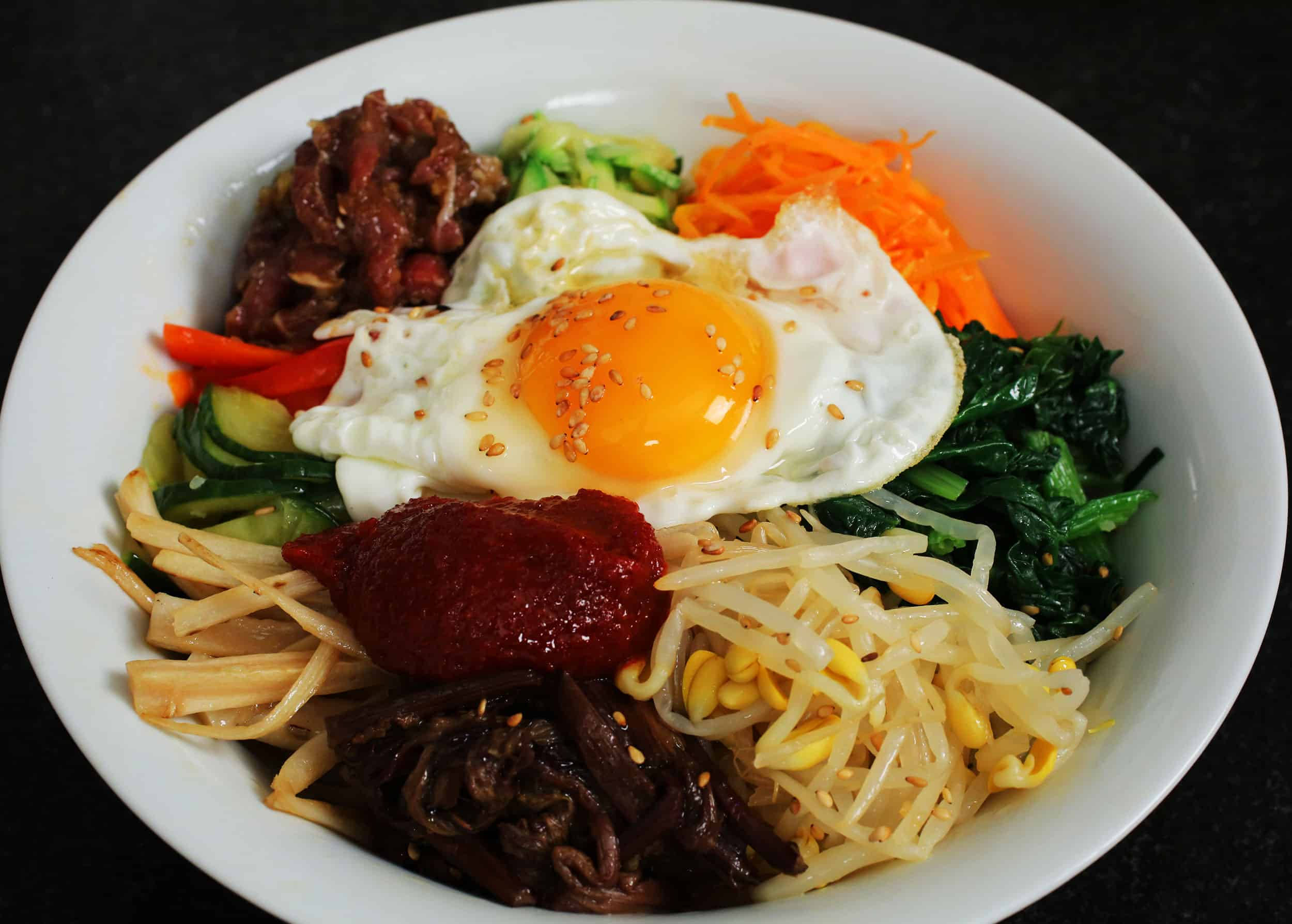 烹飪 桌布 壁紙 — 一碗色彩繽紛的韓國石鍋拌飯，上面放著太陽蛋和五顏六色的蔬菜。