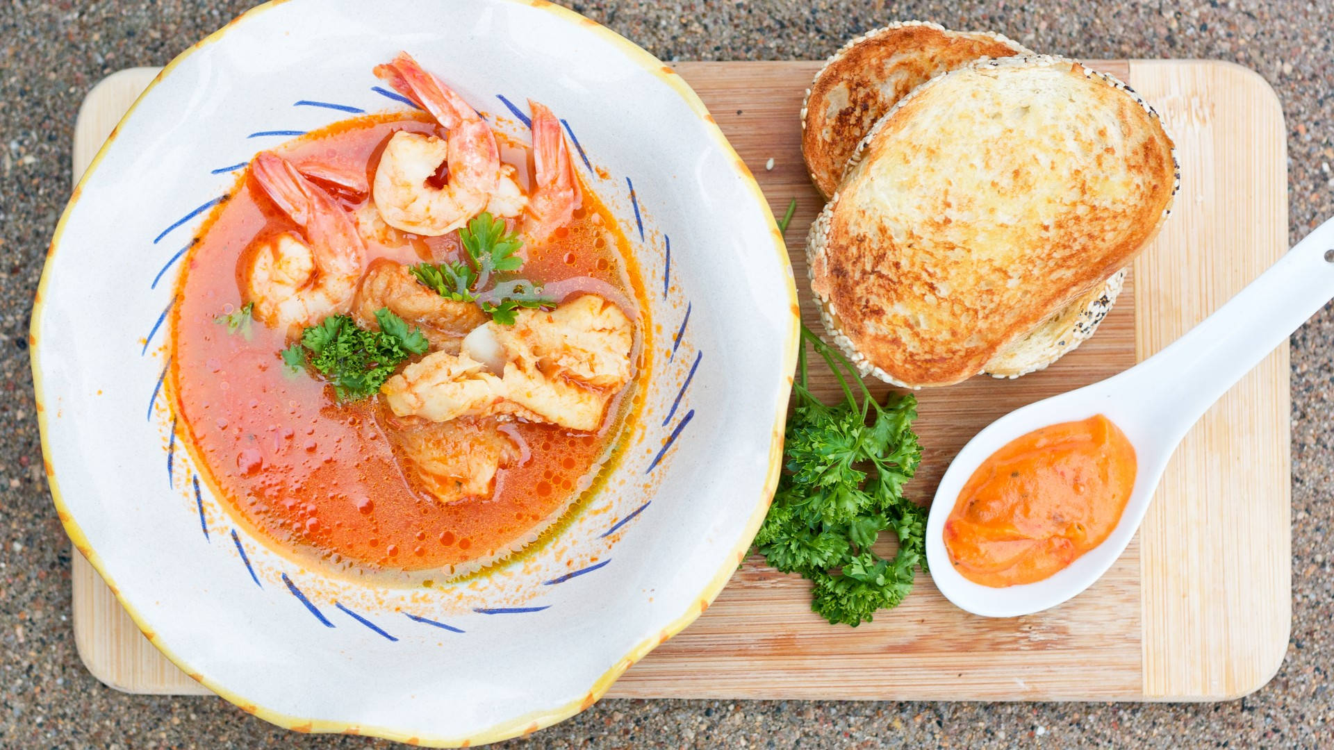 Food Photography 桌布 壁紙 — 一碗色彩鮮豔的蝦湯，飾以歐芹，旁邊放著烤麵包和一匙醬汁，置於木板上。