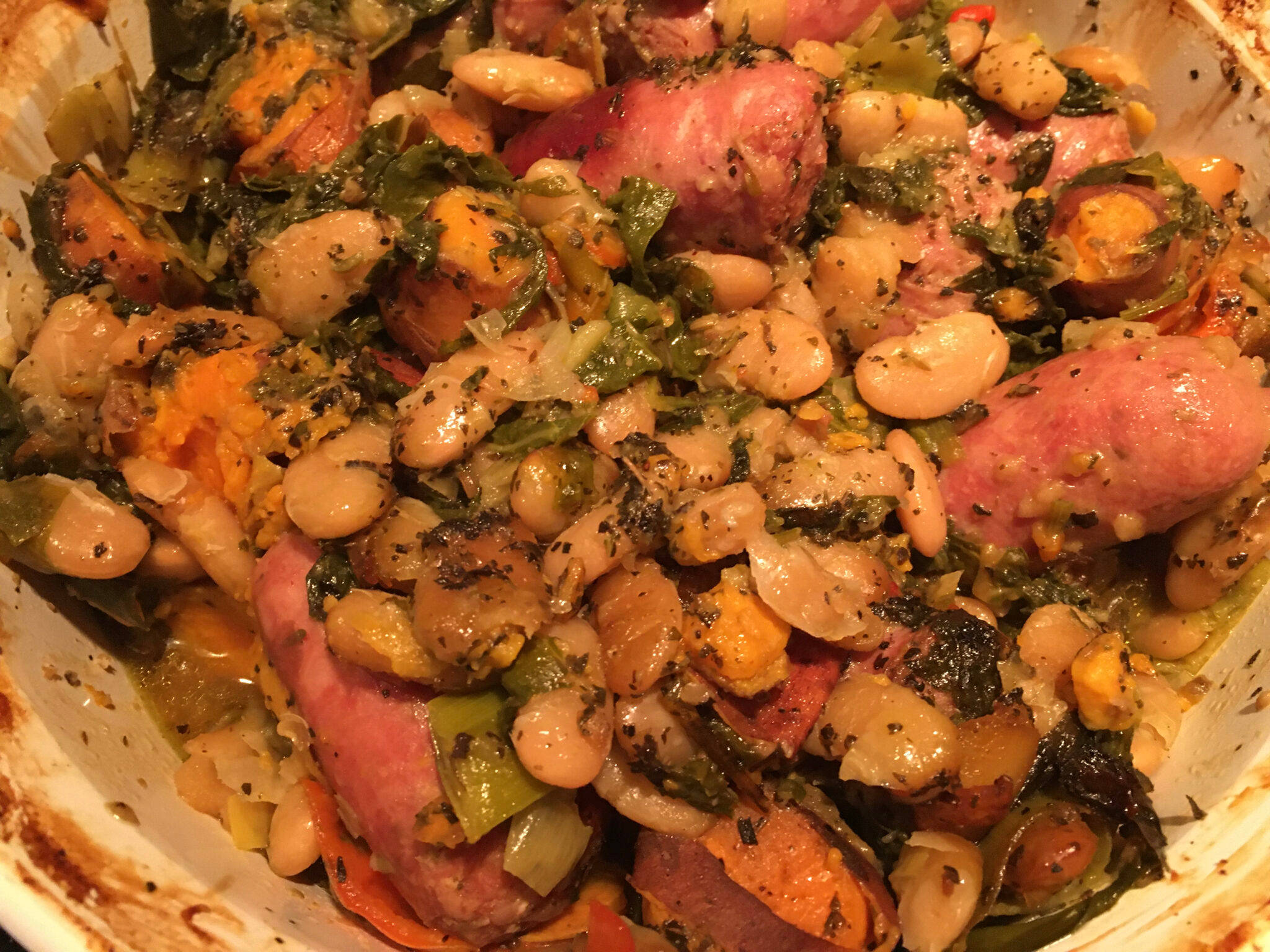 Delicious Food 桌布 壁紙 — 一碗豐盛的白豆、羽衣甘藍和香腸塊，以香草調味。