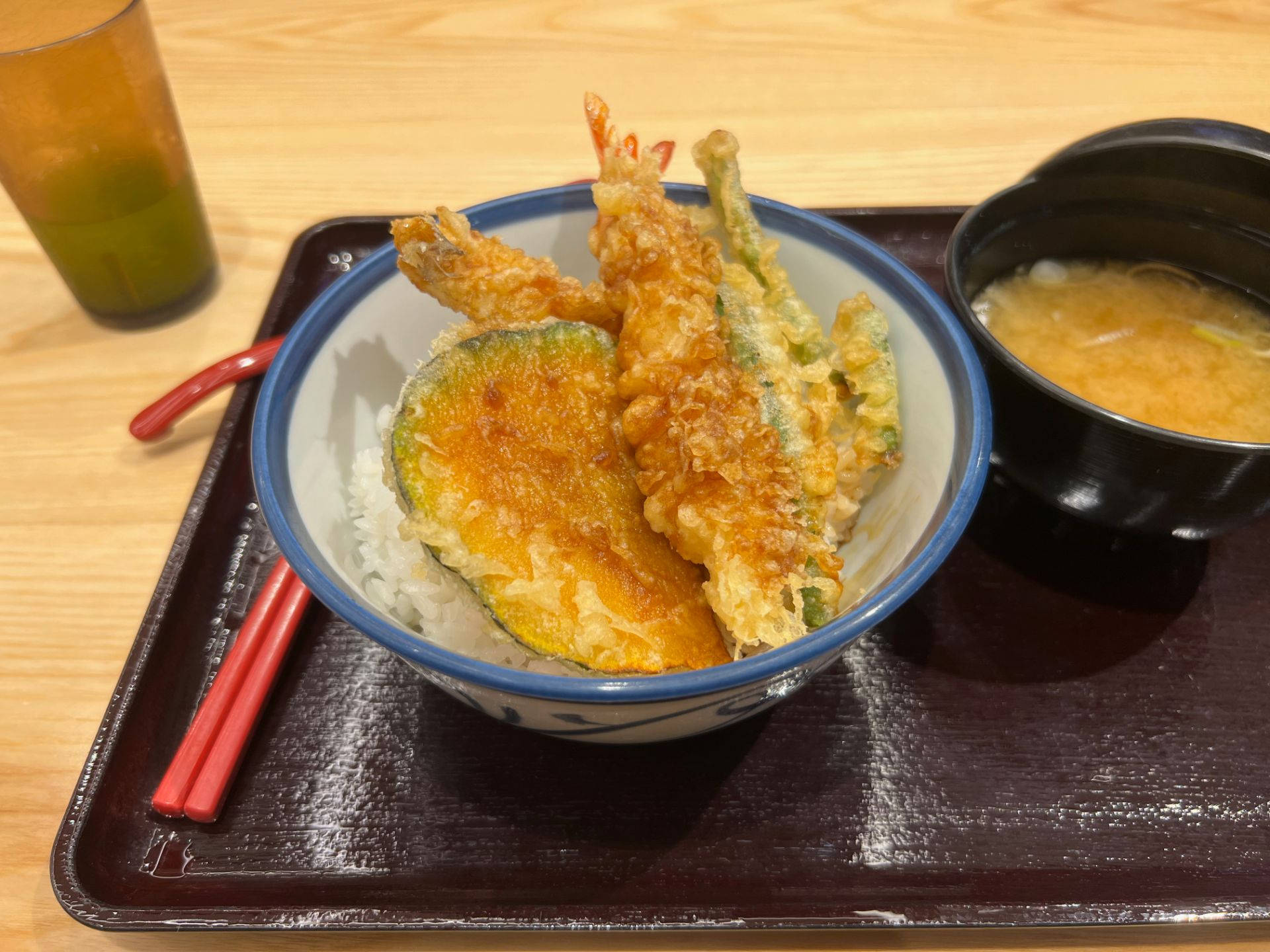shrimp 桌布 壁紙 — 一碗金黃天婦羅蝦和蔬菜放在蒸飯上，配上味噌湯和飲品，置於木托盤上。