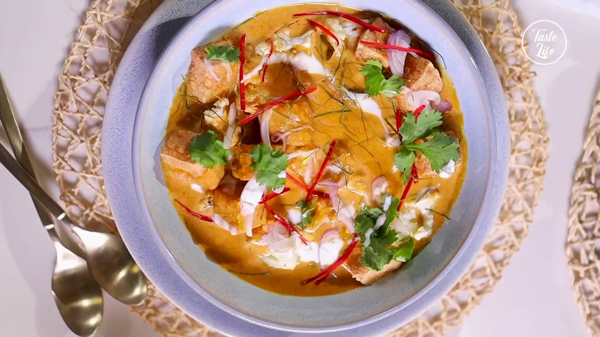 Food Photography 桌布 壁紙 — 一碗鮮橙色咖哩配豆腐，飾以香菜、紅辣椒和洋蔥，放在淺藍色碗中置於編織墊上。