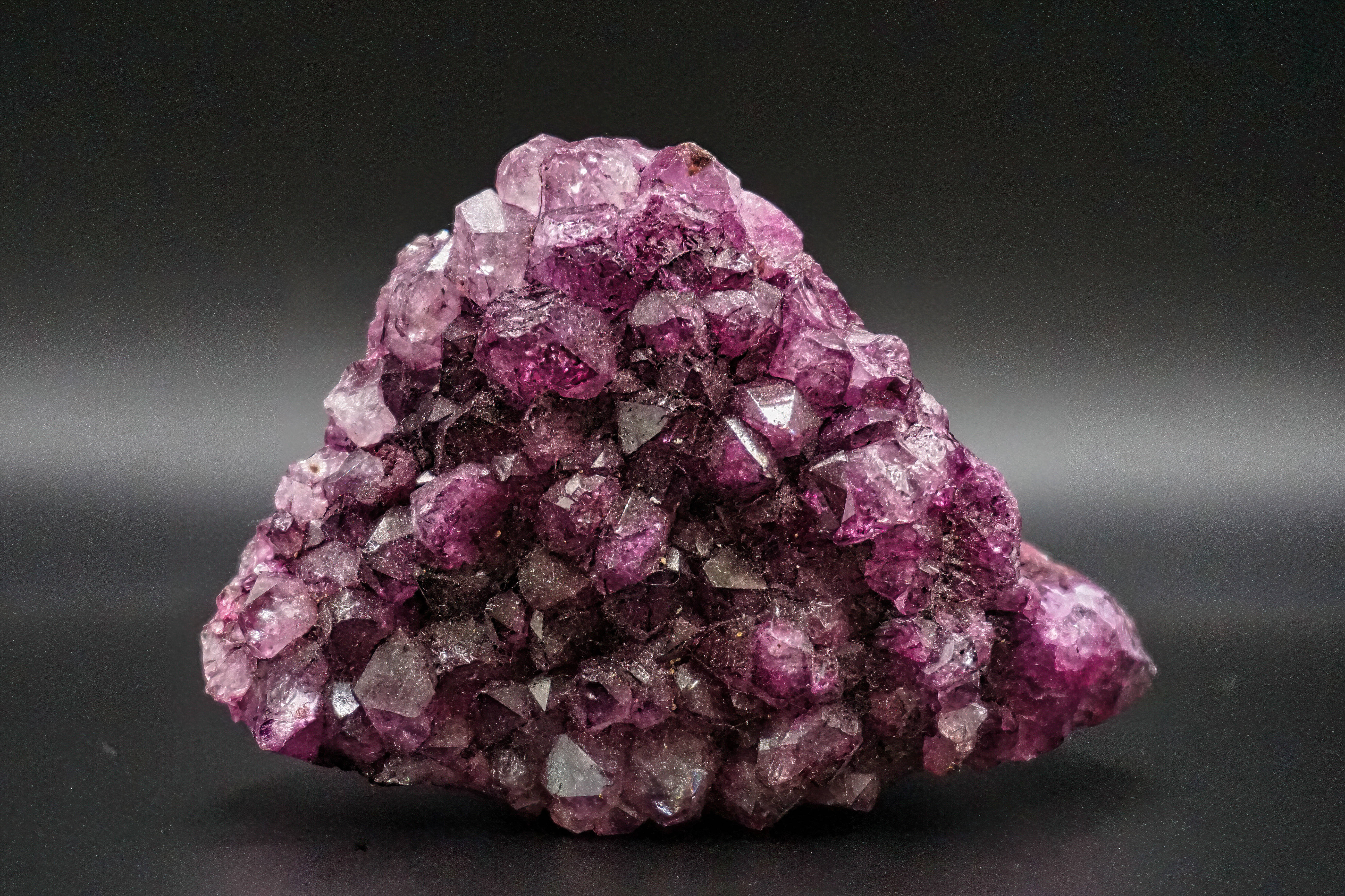 Purple Crystal 桌布 壁紙 — 一簇充滿活力的紫色紫水晶晶體在深色漸變背景上閃爍著鋒利的刻面。