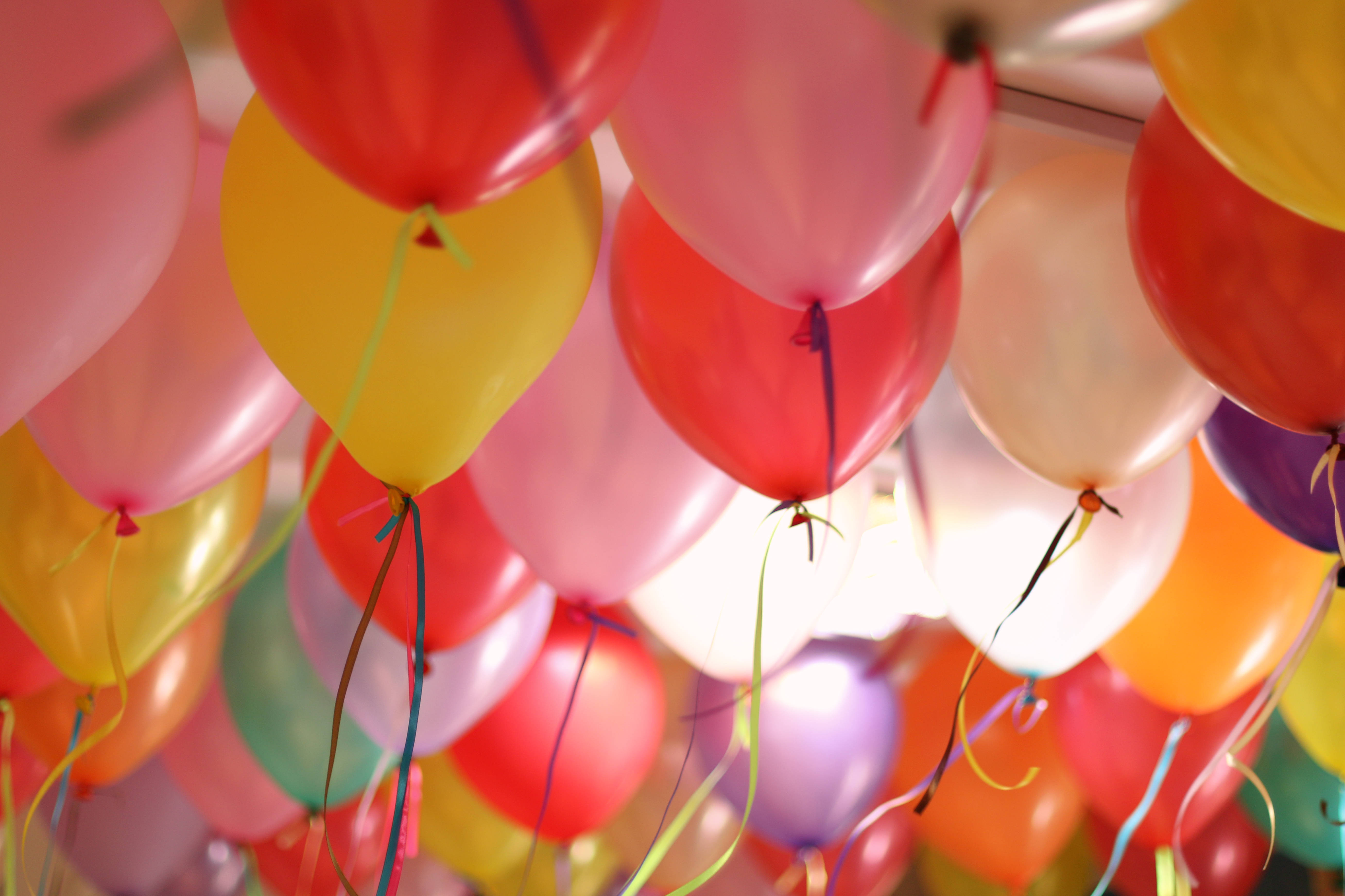 Balloon 桌布 壁紙 — 一簇色彩繽紛的乳膠氣球漂浮在頭頂，絲帶垂下，營造節日慶祝氣氛。