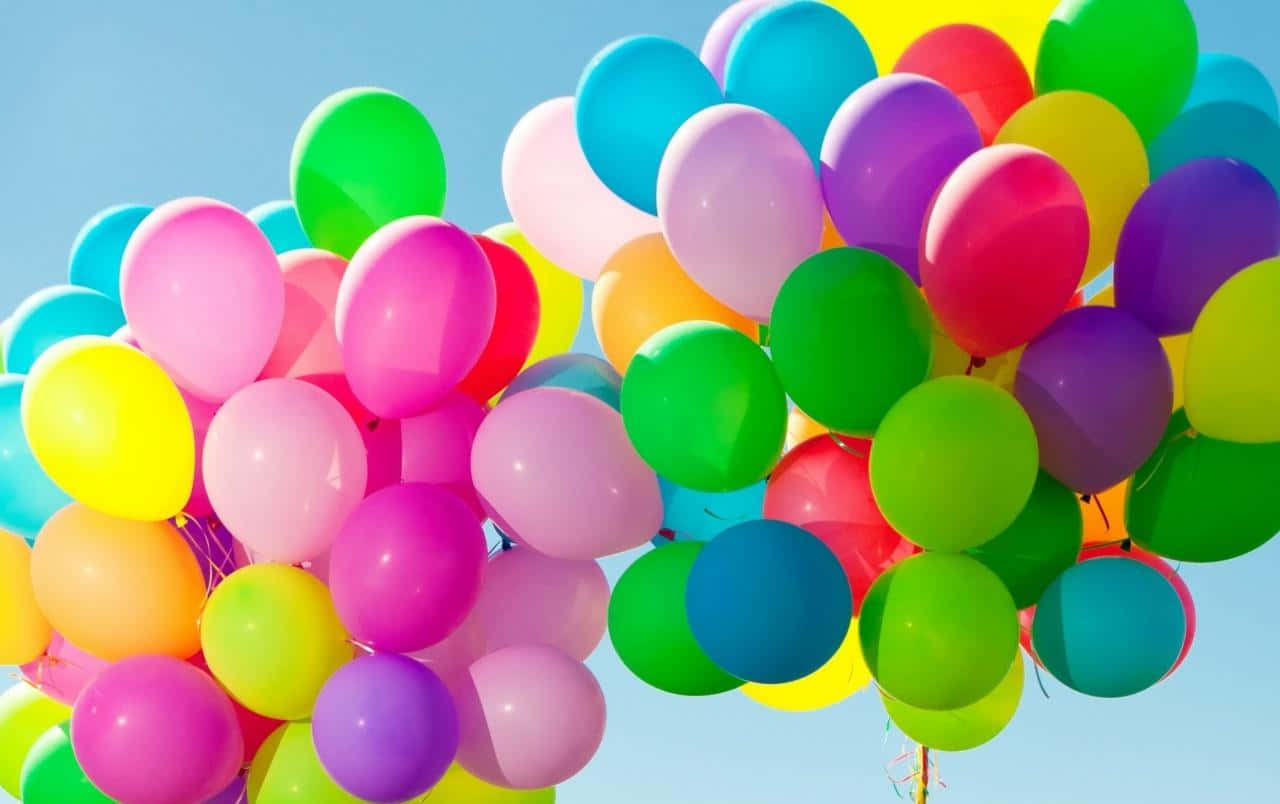 Balloon 桌布 壁紙 — 一簇色彩繽紛的氣球在清澈的藍天中飄浮，散發出歡樂的慶祝氣氛。