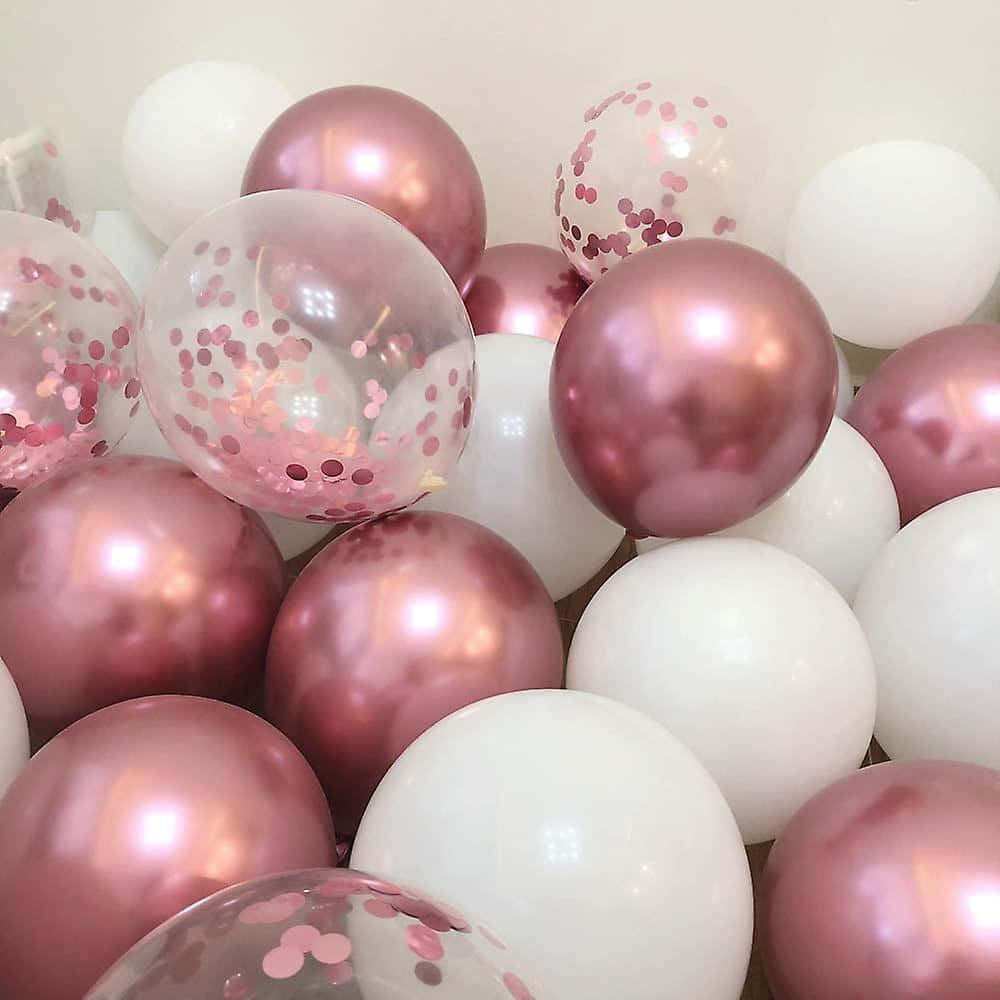 Pink Balloons 桌布 壁紙 — 一簇閃亮的玫瑰金和白色氣球，裡面有粉紅色紙屑，在柔和光線下閃耀。