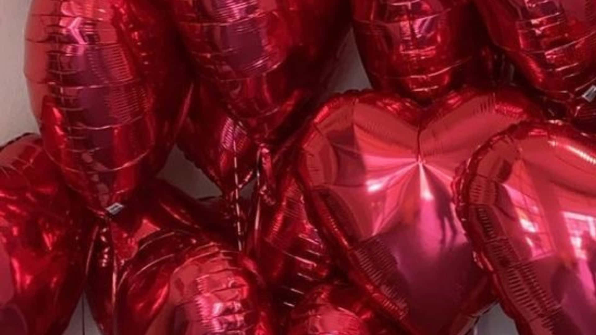 Red Hearts 桌布 壁紙 — 一簇閃亮的紅色金屬心形氣球，表面光滑，反射光線。