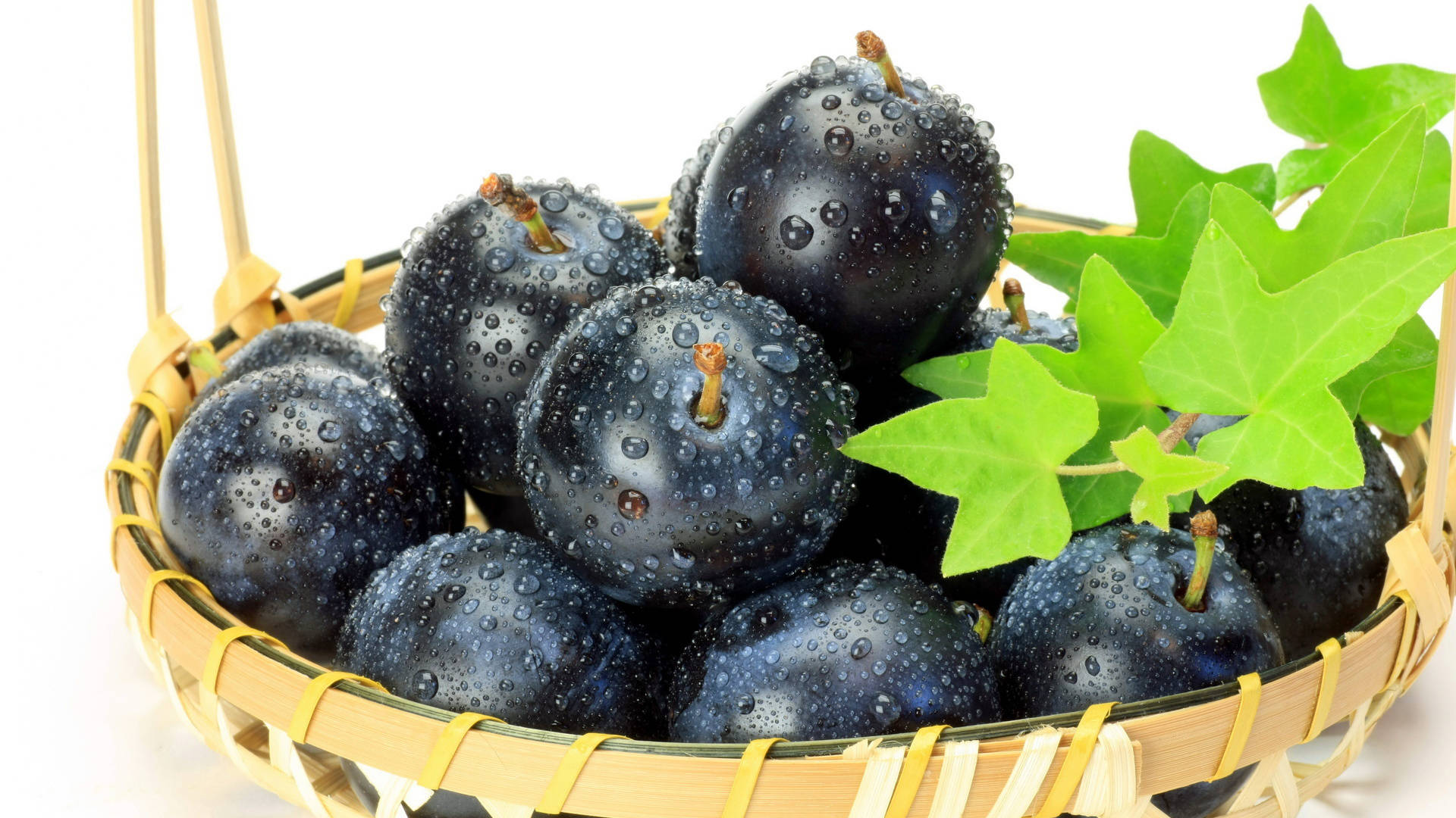 Grape 桌布 壁紙 — 一籃光澤的黑布冧，閃爍著水滴，旁邊是充滿活力的綠色常春藤葉。