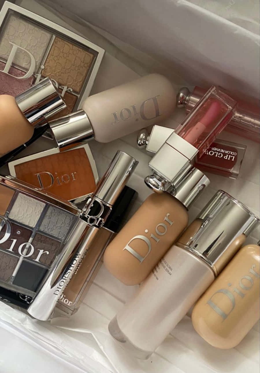 Dior 動態 桌布 壁紙 — 一系列奢華的Dior化妝品，排列在白色紋理表面上，帶有金屬裝飾和溫暖色調。