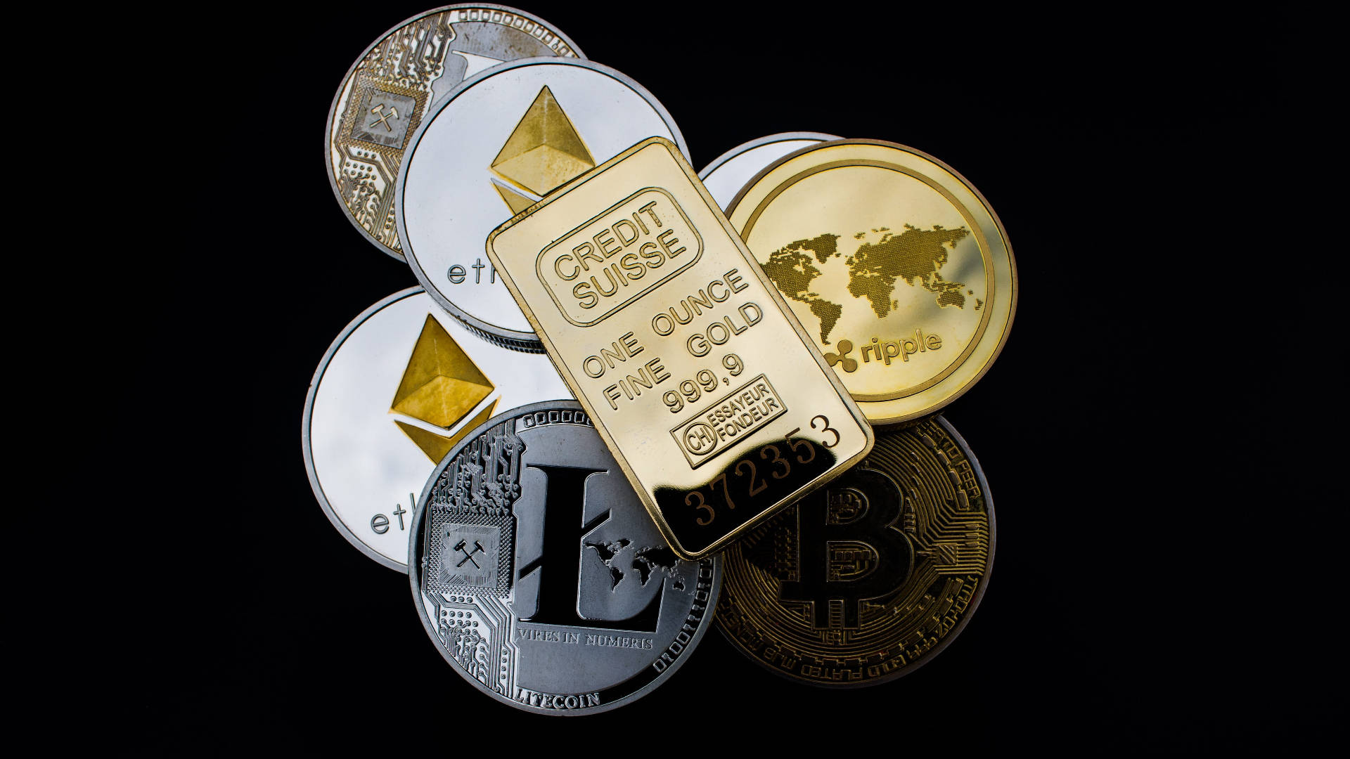 以太坊 桌布 壁紙 — 一系列實體加密貨幣硬幣和 Credit Suisse 金條排列在黑色背景上。