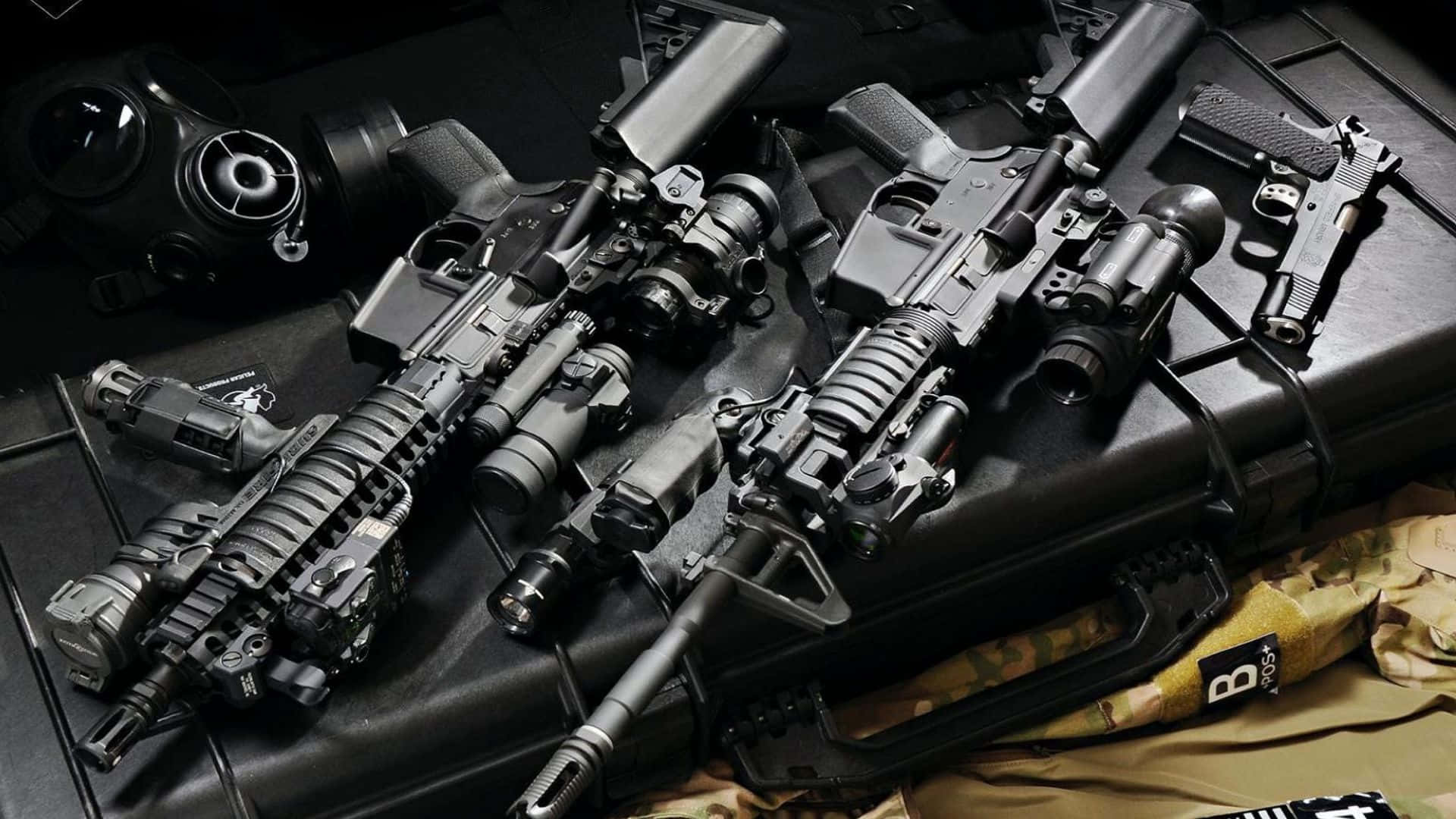 Call Of Duty Weapons 桌布 壁紙 — 一系列戰術槍械和一個防毒面具排列在一個黑色箱子上，下方有迷彩裝備。