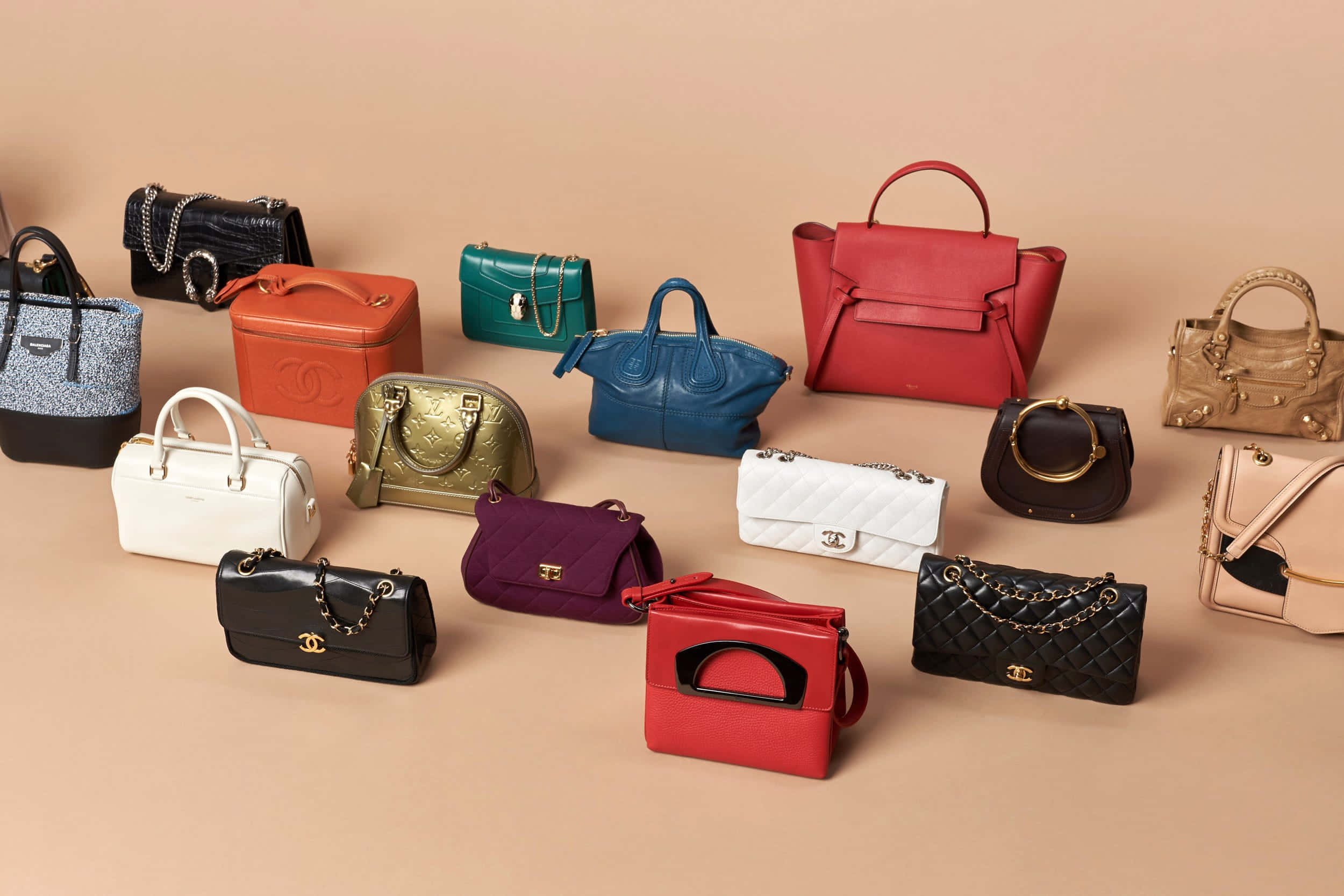 purse 桌布 壁紙 — 一系列色彩繽紛、款式多樣的奢華手提包整齊排列在米色背景上。