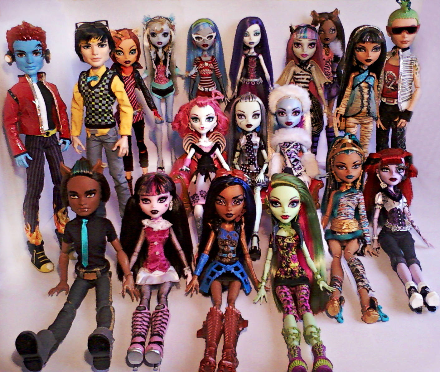bratz 美學 桌布 壁紙 — 一系列色彩繽紛的Monster High公仔在純白背景前一起擺姿勢，展現多元化的哥德式時尚和色彩繽紛的頭髮。
