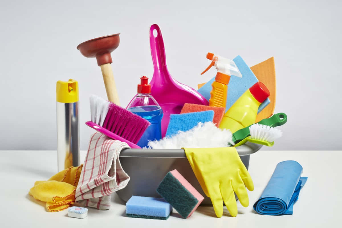 Cleaning 桌布 壁紙 — 一系列色彩繽紛的清潔工具和用品，從金屬桶中溢出，背景為純白色。