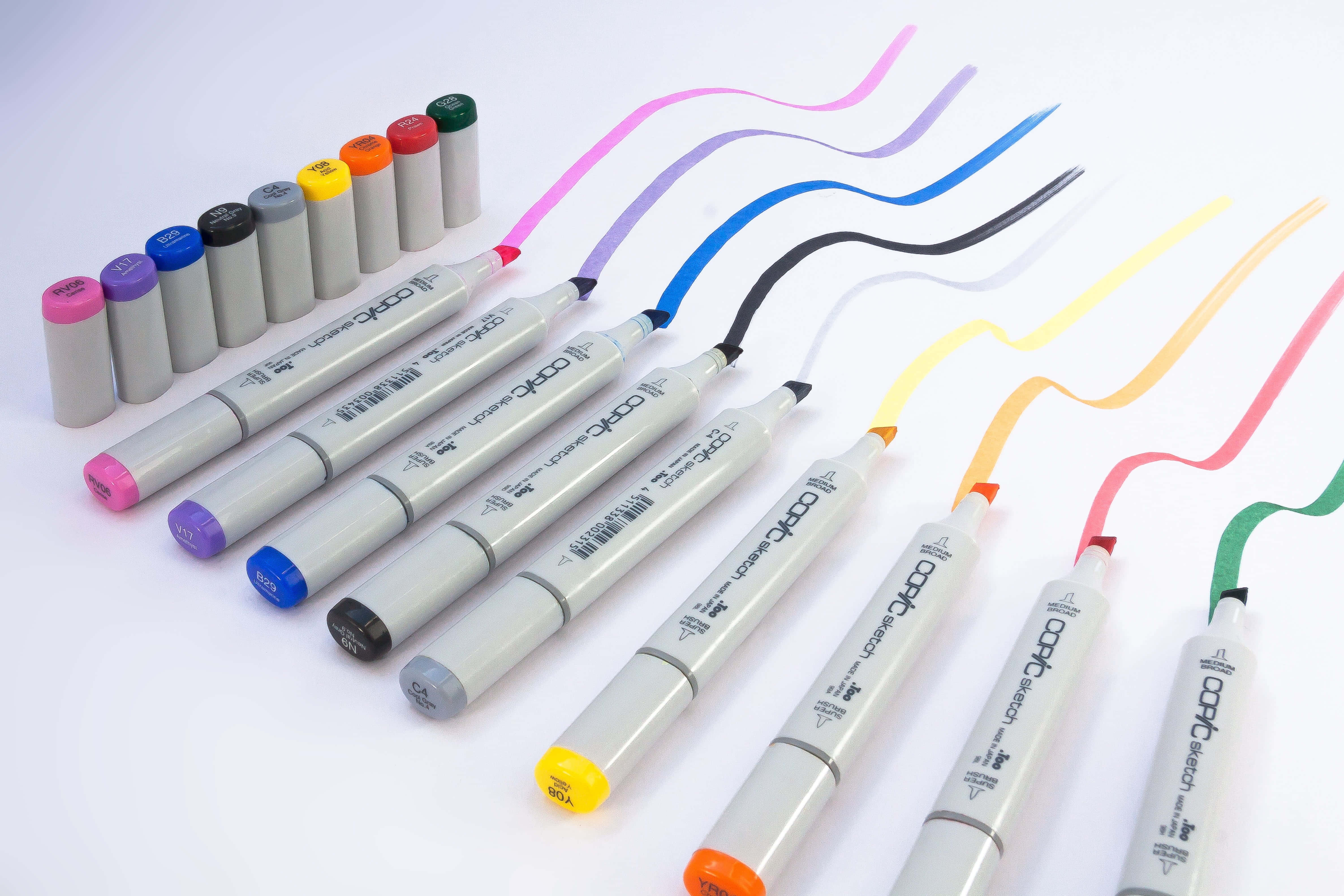 彩色動圖 桌布 壁紙 — 一系列鮮豔的Copic Sketch標記筆以對角線排列，流動的彩色線條在潔白的背景上展示其鮮豔的墨水。