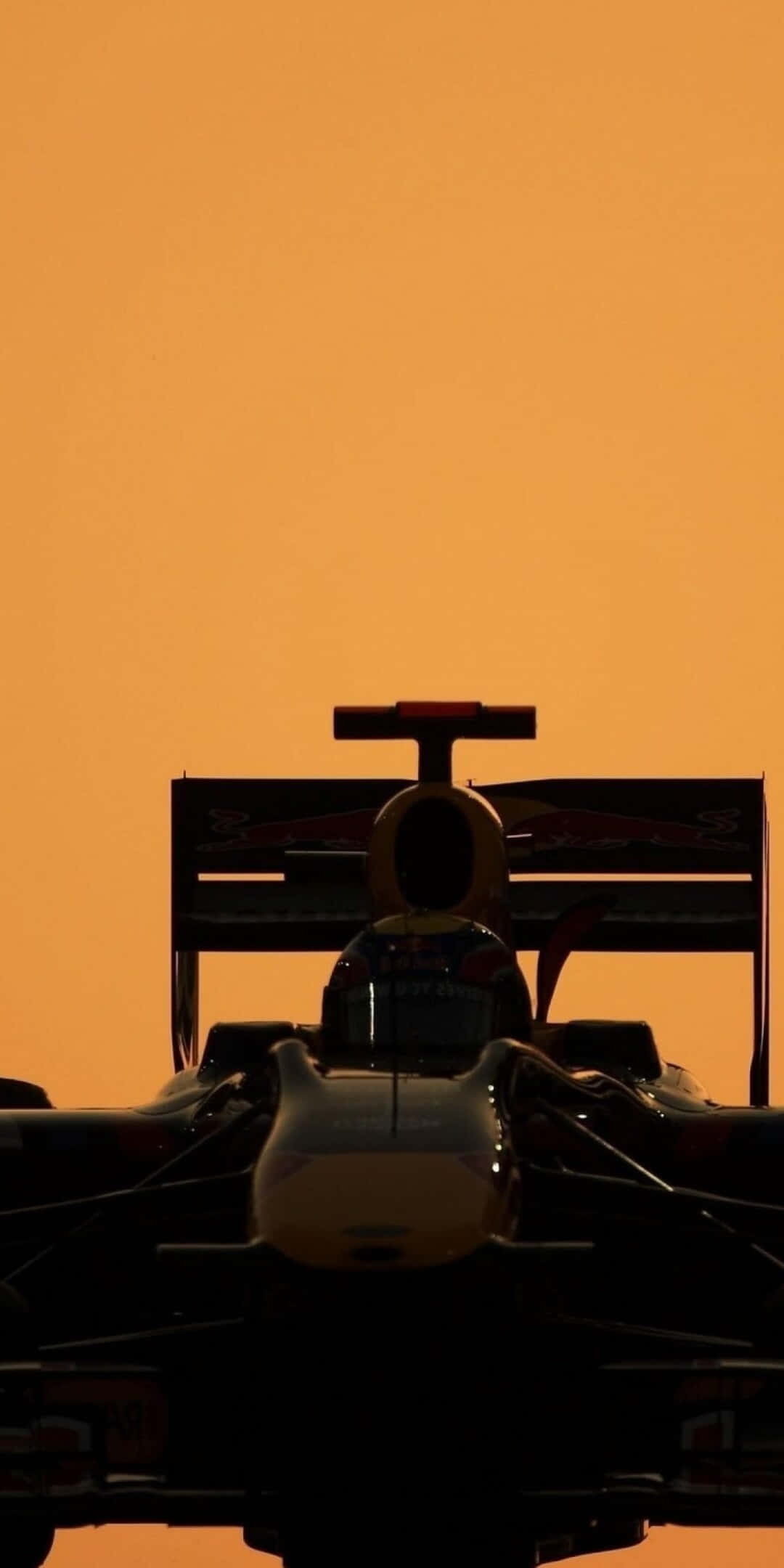 F1 桌布 壁紙 — 一級方程式賽車剪影，映襯著充滿活力的橙色日落天空。