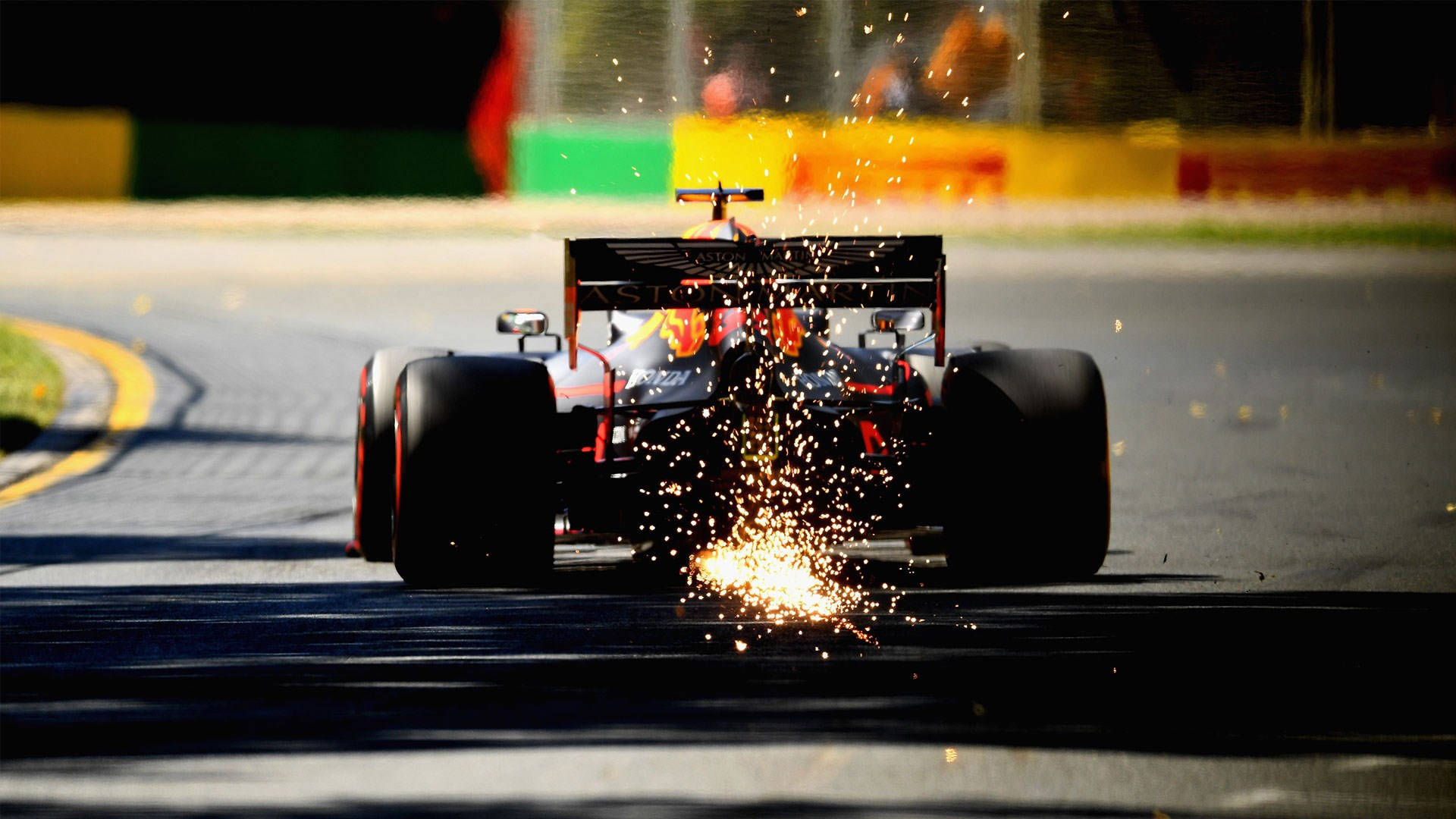 Formula One 桌布 壁紙 — 一級方程式賽車在明亮陽光下高速馳騁，後輪胎迸發出火花。