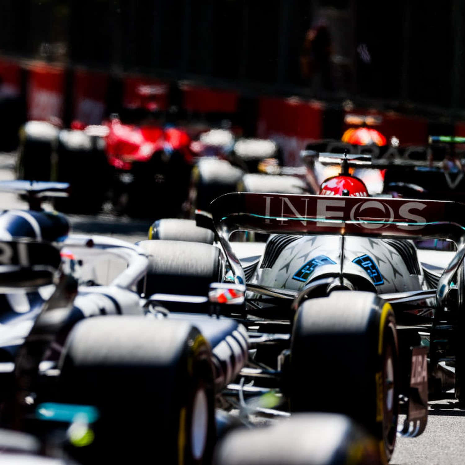 Formula One 桌布 壁紙 — 一級方程式賽車在賽道上疾馳的特寫鏡頭，背景中競爭對手模糊不清。