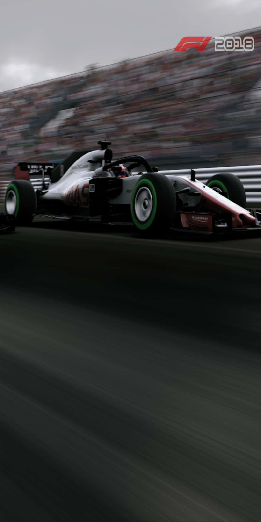 F1 桌布 壁紙 — 一級方程式賽車在賽道上高速飛馳，背景有模糊的動感和人群。