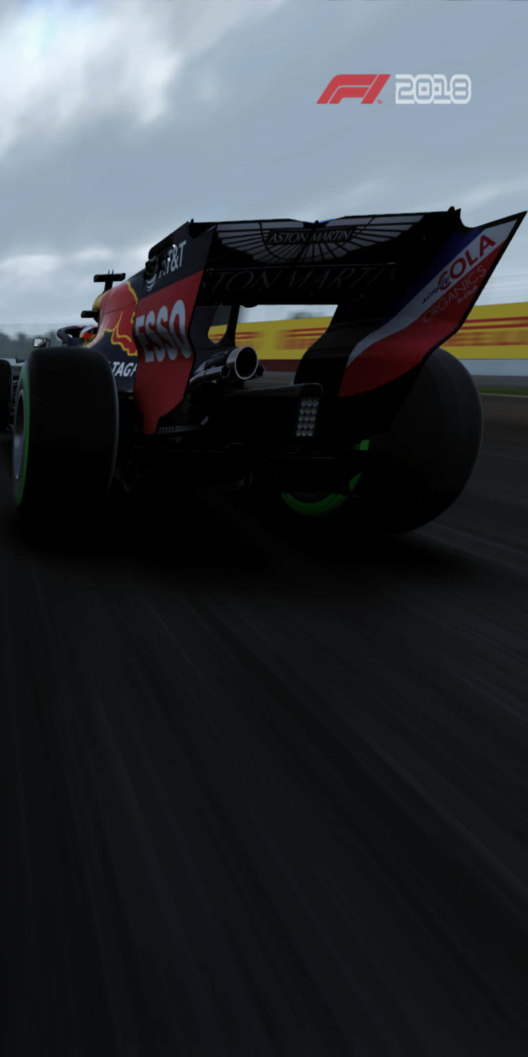 F1 桌布 壁紙 — 一級方程式賽車在陰天高速行駛在濕滑賽道上，動態模糊強調速度。