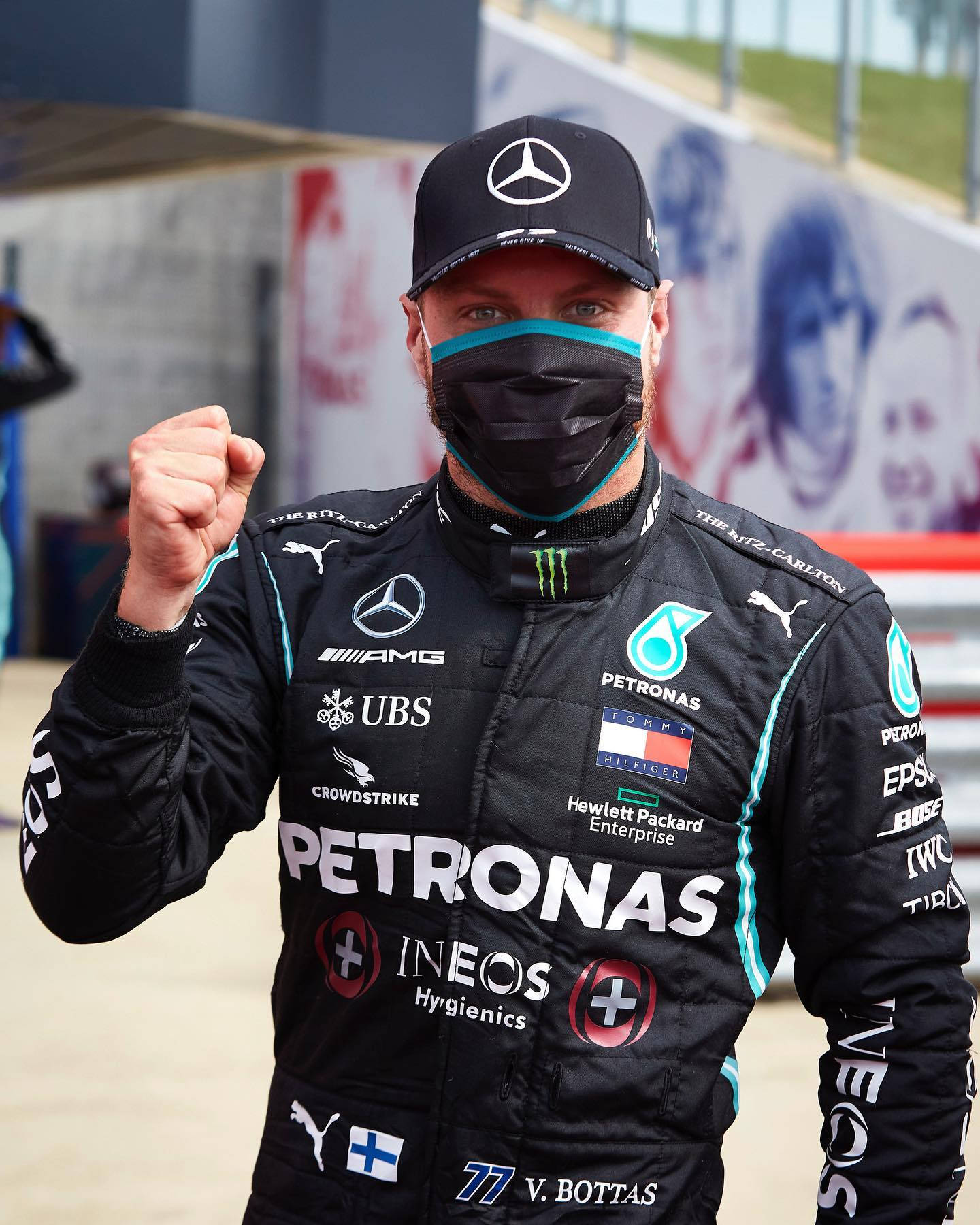 Valtteri Bottas 桌布 壁紙 — 一級方程式賽車手Valtteri Bottas身穿黑色賽車服和口罩，在賽道上舉起拳頭擺出勝利姿勢。