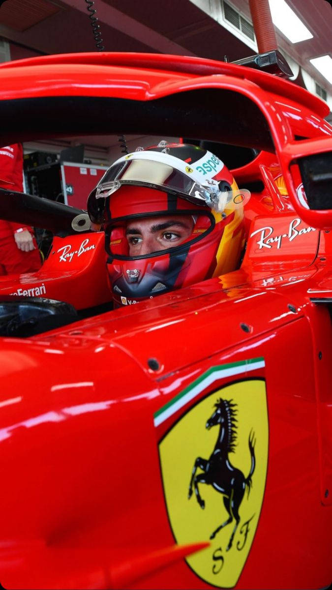F1 桌布 壁紙 — 一級方程式車手在紅色法拉利賽車中的特寫，標誌性的躍馬標誌清晰可見。